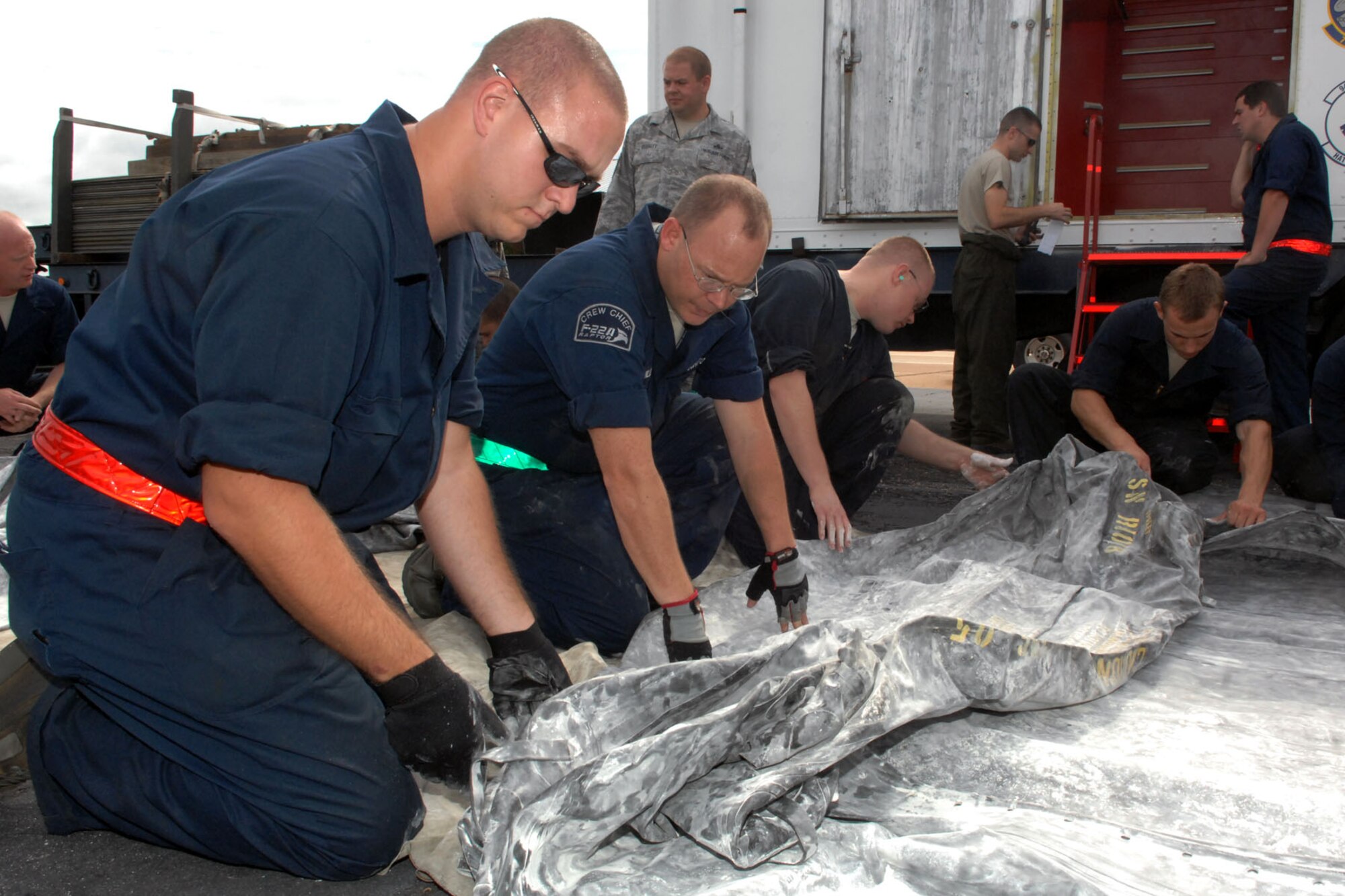 Personnel from the 1st Maintenance Squadron’s Packaged Maintenance Plan team unroll and inspect an air bag for tears during a major accident response exercise on Langley Air Force Base Va., Sept. 22, 2011. The MARE tested the base personnel’s readiness in responding to emergencies such as an aircraft crash, organizing search and rescue efforts, handling mass casualties and responding to hydrazine leaks. (U.S. Air Force photo by Staff Sgt. Jeff Nevison/Released)