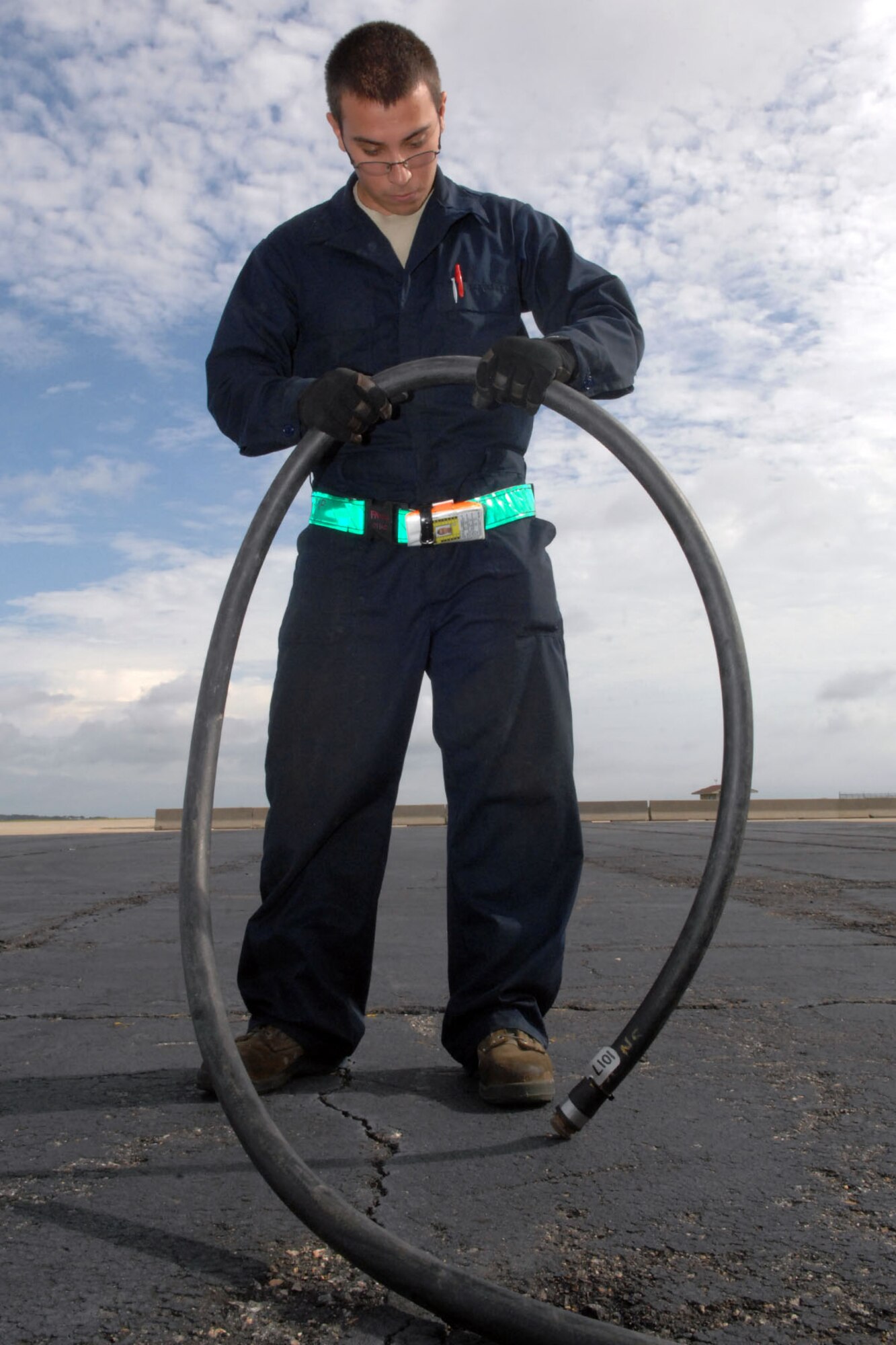 U.S. Air Force Senior Airman Francisco Morales, 1st Maintenance Squadron Packaged Maintenance Plan team member, carefully inspects an air-compressor hose prior to use during a major accident response exercise on Langley Air Force Base Va., Sept. 22, 2011. The MARE was conducted to test the base’s response time and preparedness in dealing with emergency situations. (U.S. Air Force photo by Staff Sgt. Jeff Nevison/Released)