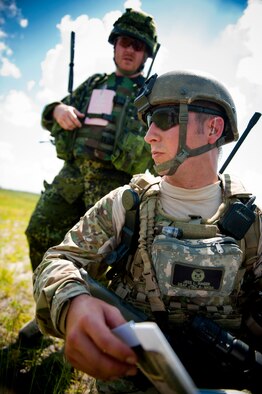 U.S. Air Force Senior Airman Jess Hager, 11th Air Support Operations Squadron joint terminal attack controller, right, turns to pay attention as Danish army Capt. Jessper Larsen, training leader, delivers a message during Exercise Atlantic Strike 11-02 at Avon Park Air Force Range, Fla., Sept. 14, 2011. Acting as ground commander, Larsen gave commands and guided new joint terminal attack controllers who directed close-air support. Larsen also used small explosives and random changes in operations status to add an element of stress to the training exercise. (U.S. Air Force photo by Staff Sgt. Jamal D. Sutter/Released)  