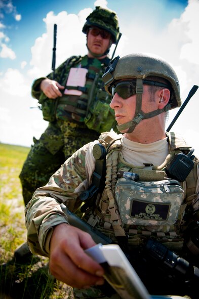 U.S. Air Force Senior Airman Jess Hager, 11th Air Support Operations Squadron joint terminal attack controller, right, turns to pay attention as Danish army Capt. Jessper Larsen, training leader, delivers a message during Exercise Atlantic Strike 11-02 at Avon Park Air Force Range, Fla., Sept. 14, 2011. Acting as ground commander, Larsen gave commands and guided new joint terminal attack controllers who directed close-air support. Larsen also used small explosives and random changes in operations status to add an element of stress to the training exercise. (U.S. Air Force photo by Staff Sgt. Jamal D. Sutter/Released)  