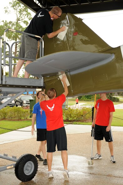 U.S. Air Force Airmen from the Senior Airman Jason D. Cunningham Airmen Leadership School class 11-G work together to clean static displays at Moody Air Force Base, Ga., Sept. 22, 2011. The students washed the heritage aircraft as part of a spirit project to keep the President George W. Bush Air Park at Moody Field clean and presentable. (U.S. Air Force photo by Senior Airman Ciara Wymbs/Released)