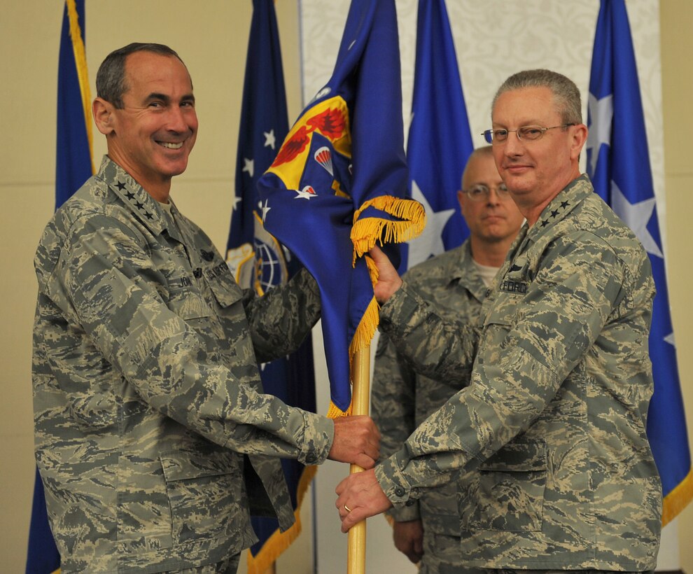 SCOTT AFB, Ill. - Gen. Raymond E. Johns, Jr., Commander of Air Mobility Command (left) passes the 18th Air Force flag to Lt. Gen. Mark F. Ramsay, during a change of command ceremony at the Scott Club here Sept. 23. Ramsay is the 18th Air Force's sixth commander, and is responsible for a worldwide operational mission conducted by more than 43,000 active-duty Airmen and approximately 1,300 airlift and air refueling aircraft. (U.S. Air Force Photo/Airman 1st Class Divine Cox).
