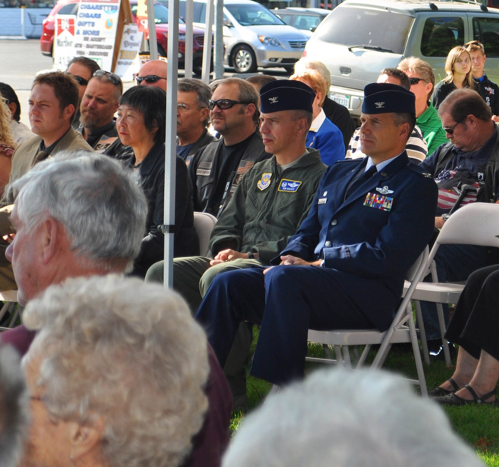 TRAVIS AIR FORCE BASE, Calif. --Col. Al Lupenski, in blues, listens to Mel Raimundo speak about his experience as a prisoner of war, at the Sept. 16, 2011 observance of National POW/MIA Recognition Day, in Vacaville, Calif. The 349th Operations Group commander, the colonel joined other Travis leaders and Airmen to honor POWs and missing in action heroes, of which 83.000 remain unaccounted for since World War II through the Cold War. Raimundo, an ambulance driver, spent five months in Stalag 4B, in Germany, from 1944 to 1945. (U.S. Air Force photo/Senior Master Sgt. Ellen L. Hatfield)