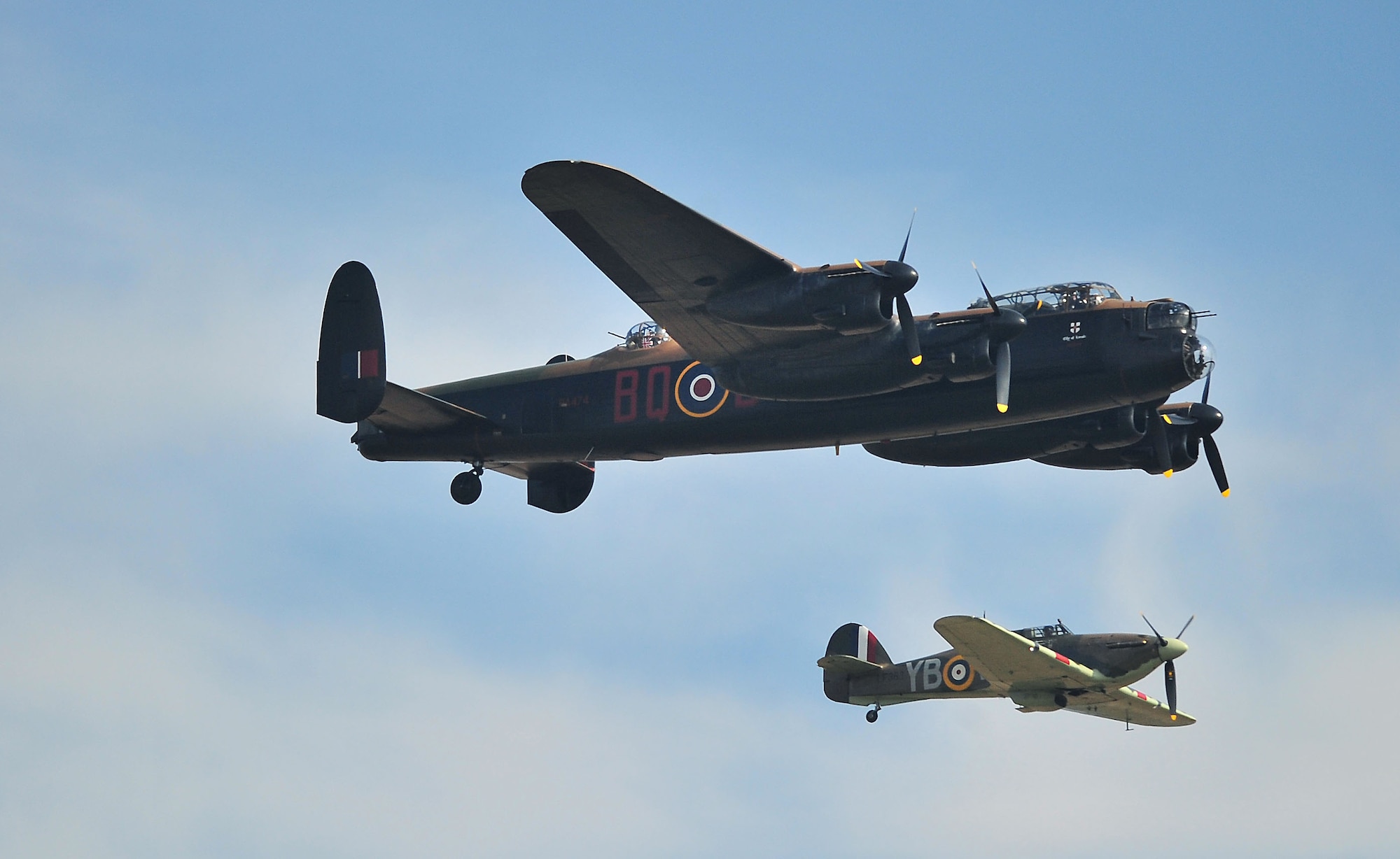 An Avro Lancaster and a DHC-1 Chipmunk fly in the Battle of Britain dedication formation during the Duxford Air Show at village in Cambridgeshire, England Sept.3. During World War II, Americans joined the Royal Air Force to help the allied powers in a fight against the axis powers, before America officially entered into the war Dec. 7, 1941. One of the many training locations in England, Duxford was later used by the United States Army Air Force to launch B-17 attacks on Germany. (U.S. Air Force photo by Senior Airman Marissa Tucker)