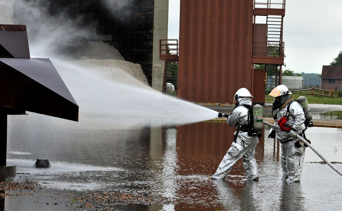 U.S Air Force Airman 1st Class Michael Costello, 633rd Civil Engineer Squadron firefighter, and Antonio Ortiz, 633rd Civil Engineer Squadron lead firefighter, put out a fire during a mock aircraft mishap at Langley Air Force Base, Va., Sept. 22, 2011. This mishap tested first responders’ overall readiness, concentrating on speed and accuracy. (U.S. Air Force photo by Airman 1st Camilla Griffin/Released)