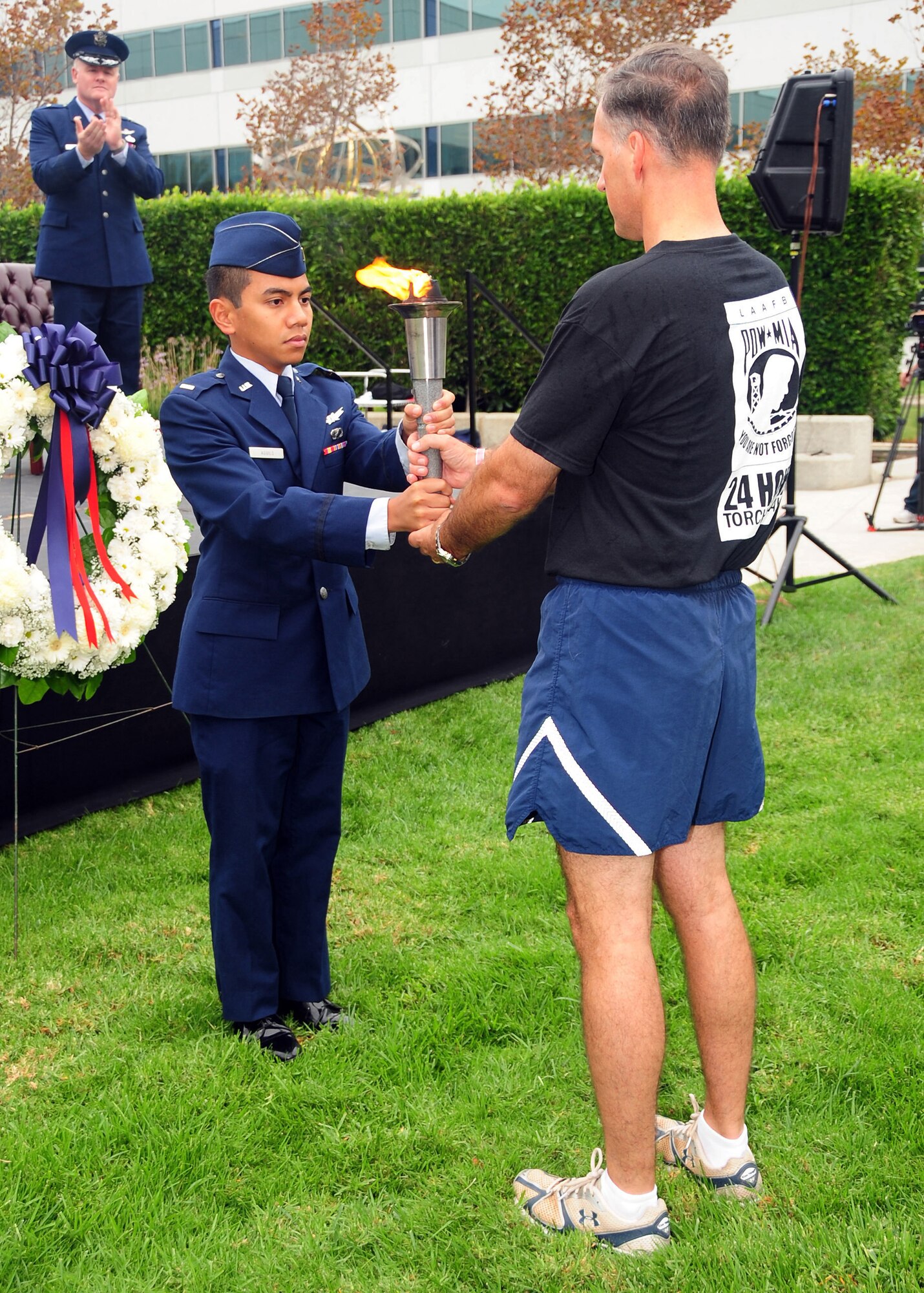 Col. Bernard Gruber, GPS director, hands off the torch following the completion of the 24-hour run. The torch was carried from Terminal Island to LAAFB by relay teams comprised of members from all Armed Forces.  (Photo by Jim Gordon)