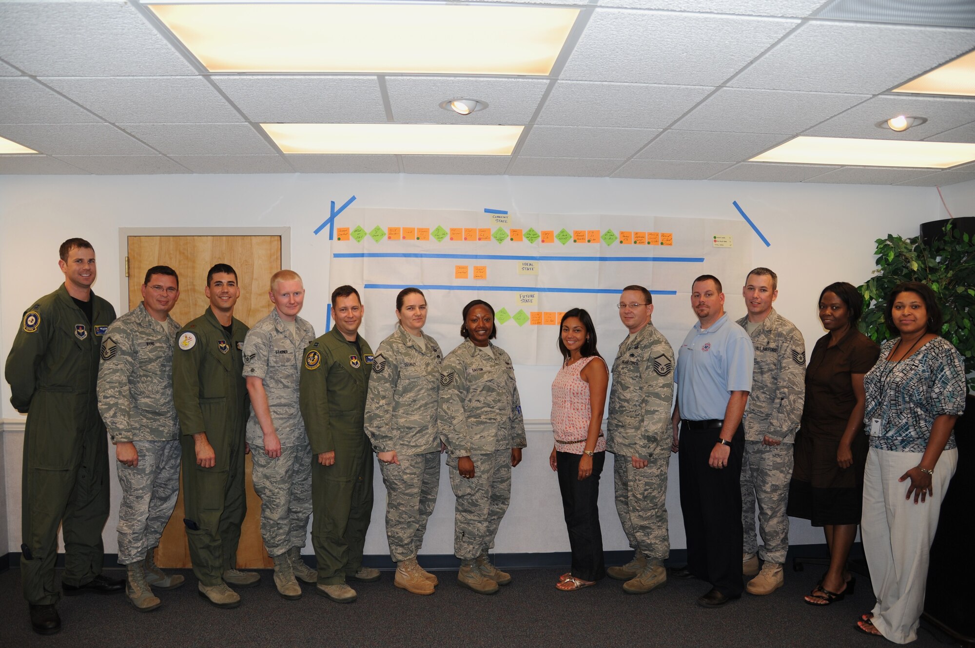 The thirteen members of the Air Force Smart Operations for the 21st Century Records Management team stand proudly in front of the process improvement board. 
