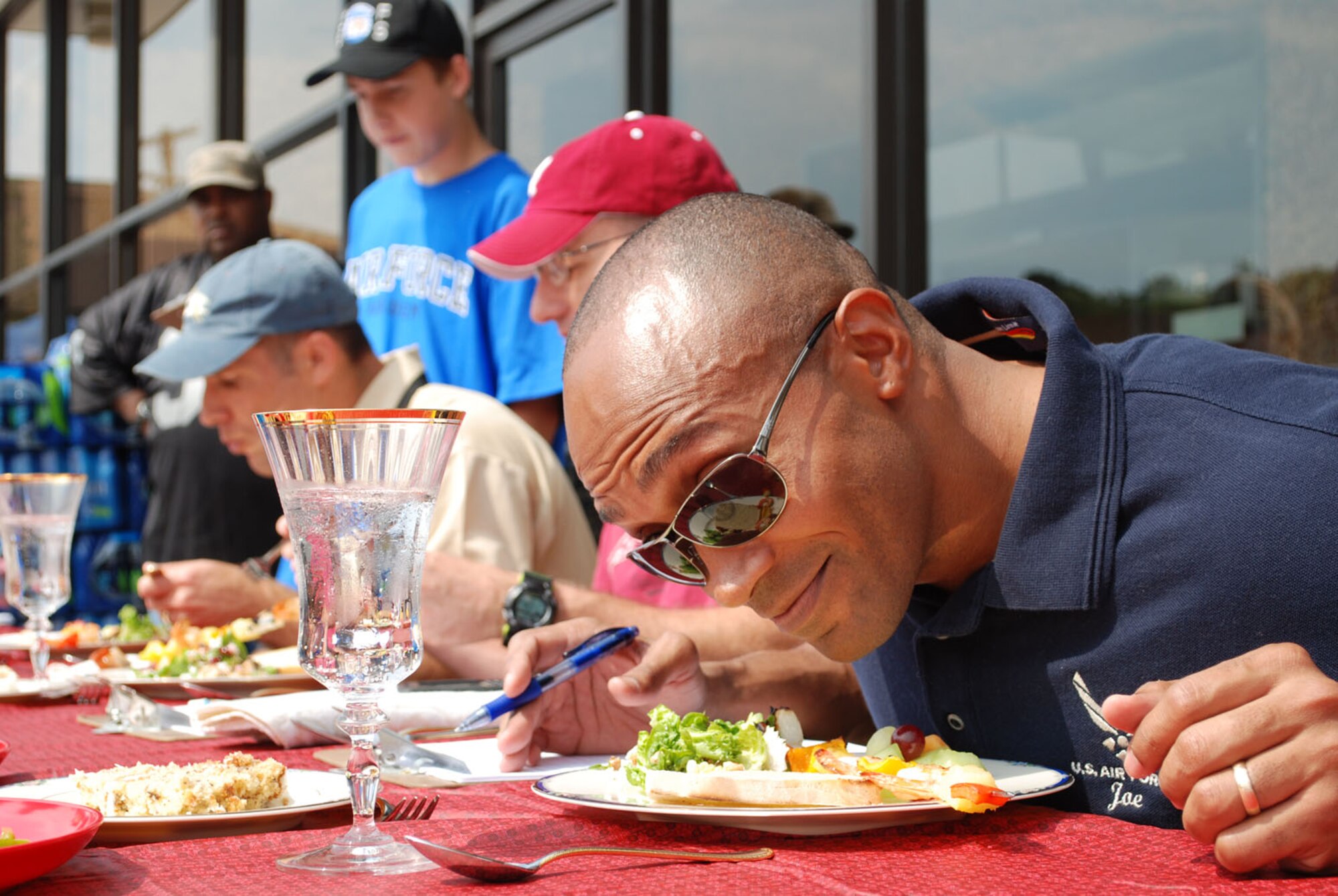 Maj. Joseph Ringer, 14th Security Forces Squadron Commander, delights in the cooking contest entries he judged with Col. Matthew Isler, 14th Flying Training Wing Vice Commander and Chief Master Sgt. Leonard Thibodeaux, 14th FTW Interim Command Chief on Sept. 17 at the "Get Your Grill On! Tailgate Cooking and Decoration Contest."  This event was a joint venture between the 14th Force Support Squadron, the base Exchange and Commissary featuring the Mississippi State football mascot, bully, jumpers, games, prizes and more. (U.S. Air Force photo/ Gwen Granderson)