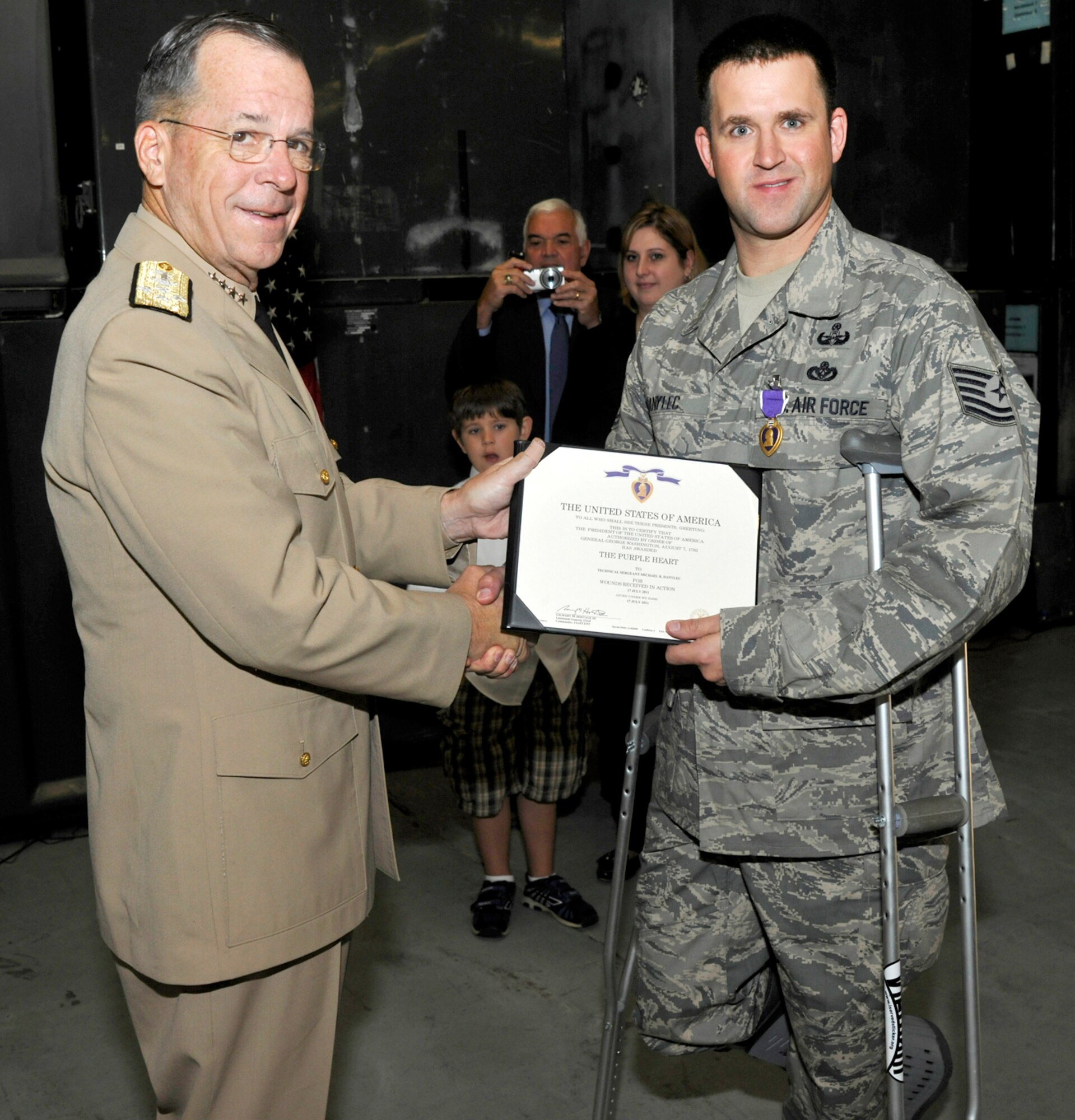 Admiral Mike Mullen, Chairman of the Joint Chiefs of Staff, shakes hands with Tech Sgt. Michael Danylec, 11th Civil Engineer Squadron Explosive Ordnance Disposal technician, after presenting Danylec with the Purple Heart on Sept. 16.  Danylec was severly injured while disarming an improvised explosive device while deployed to the Kandahar Province in Afghanistan.  (U.S. Air Force Photo/Airman 1st Class Lindsey Beadle)