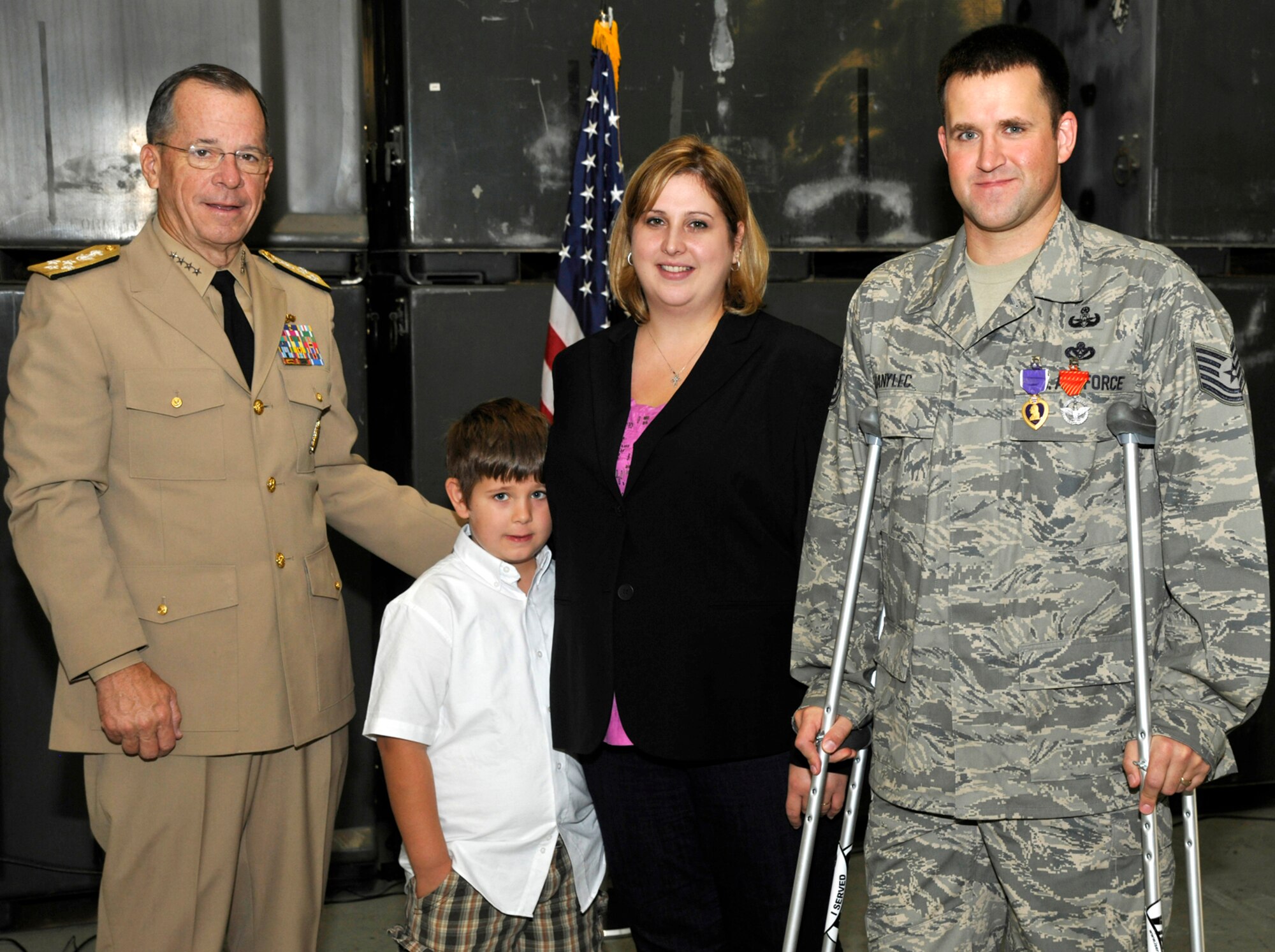Admiral Mike Mullen, Chairman of the Joint Chiefs of Staff, stands with Tech Sgt. Michael Danylec, 11th Civil Engineer Squadron Explosive Ordnance Disposal technician, and his family after presenting Danylec with the Purple Heart on Sept. 16.  Danylec was severly injured while disarming an improvised explosive device while deployed to the Kandahar Province in Afghanistan.  (U.S. Air Force Photo/Airman 1st Class Lindsey Beadle)