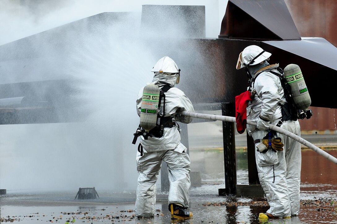 U.S. Air Force Airman 1st Class Michael Costello, 633rd Air Base Wing Civil Engineer Squadron fire fighter, and Antonio Ortiz, 633rd ABW CES lead fire fighter, eliminate a simulated aircraft fire during an exercise at Langley Air Force Base, Va., Sept. 22, 2011.  The major accident response exercise was designed to evaluate the base's ability to respond to an aircraft mishap that involves several interconnected incidents.  (U.S. Air Force photo by Airman 1st Class Kayla Newman/Released)