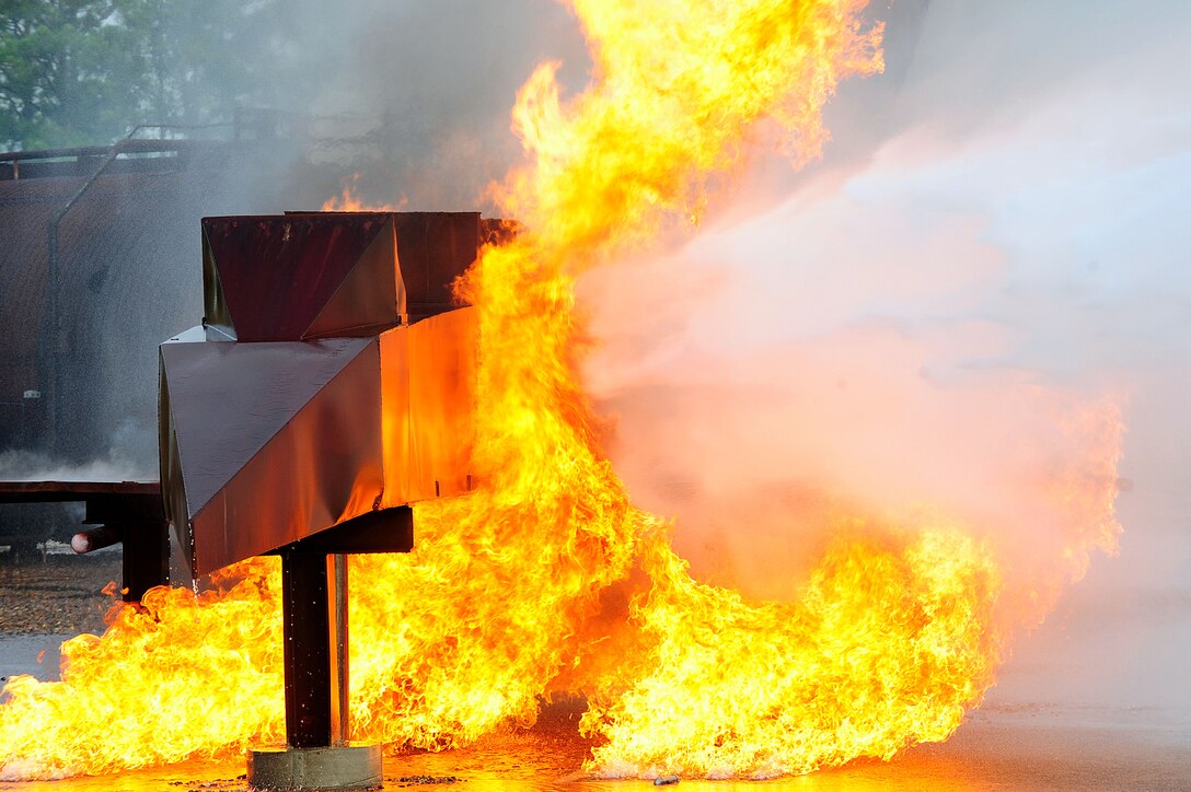 Flames engulf the aircraft simulator as fire fighters from the 633rd Civil Engineer Squadron attempt to extinguish the blaze during a major accident response exercise at Langley Air Force Base, Va., Sept. 22, 2011. The exercise was designed to improve the base’s preparedness for multiple emergency situations. (U.S. Air Force photo by Airman 1st Class Kayla Newman/Released)