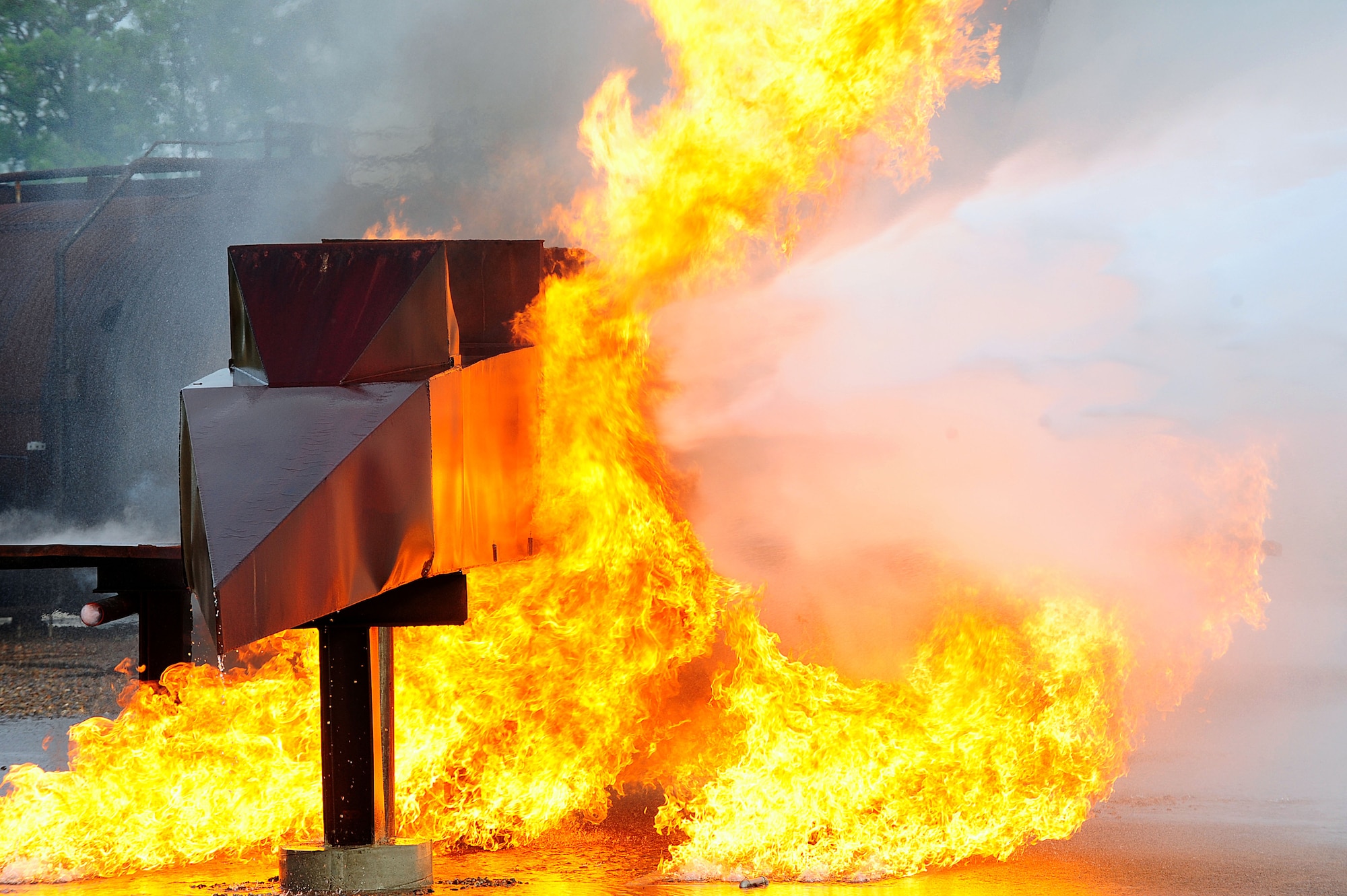 Flames engulf the aircraft simulator as fire fighters from the 633rd Civil Engineer Squadron attempt to extinguish the blaze during a major accident response exercise at Langley Air Force Base, Va., Sept. 22, 2011. The exercise was designed to improve the base’s preparedness for multiple emergency situations. (U.S. Air Force photo by Airman 1st Class Kayla Newman/Released)