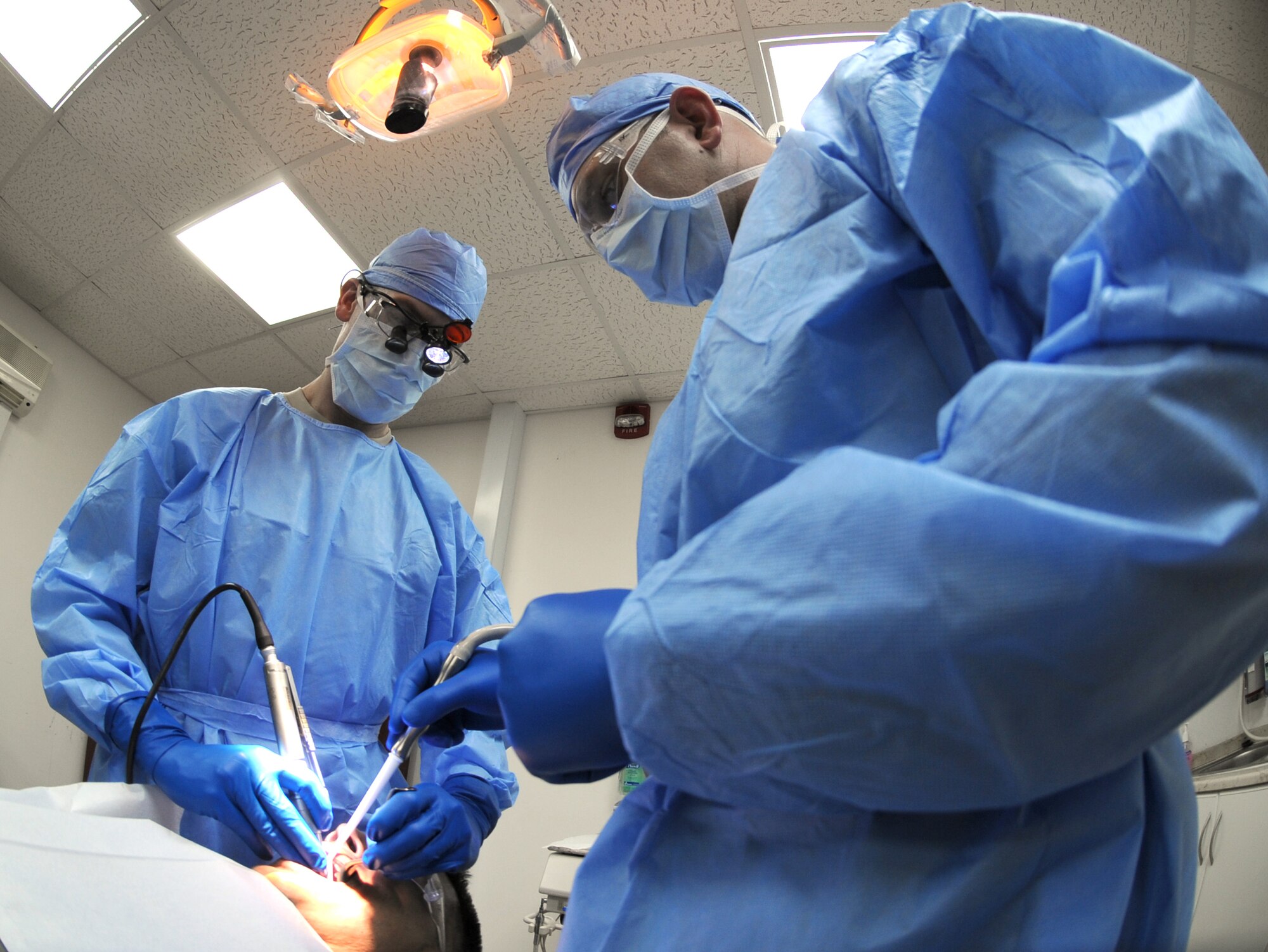 Maj. (Dr.) Bradshaw Stout, the 380th Expeditionary Medical Group dentist, performs a surgical extraction on a patient Sept. 22, 2011, at the new dental clinic at an air base in Southwest Asia. Stout is assisted by Master Sgt. S. Dwayne Shrewsbury, the NCO in charge of aerospace medicine for the 380th EMDG. The clinic provides emergency dental care to the deployed Airmen, Soldiers and Sailors at the base, and will save the wing approximately $15,000 a month. Prior to the clinic's opening, patients were sent off base for dental care. (U.S. Air Force photo/Master Sgt. Chance Babin)