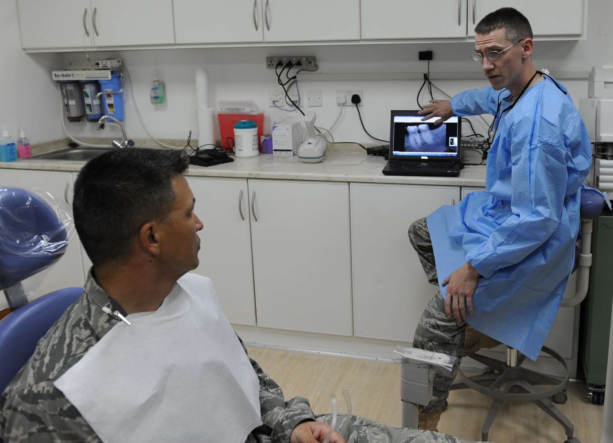 Maj. (Dr.) Bradshaw Stout, the 380th Expeditionary Medical Group dentist, performs an x-ray analysis with a patient prior to performing a medical procedure Sept. 22, 2011 at the new dental clinic at the 380th Air Expeditionary Wing in Southwest Asia. The clinic provides emergency dental care to the deployed Airmen, Soldiers and Sailors at the base, and will save the wing approximately $15,000 a month. Prior to the clinic's opening, patients were sent off base for dental care. (U.S. Air Force photo/Master Sgt. Chance Babin)