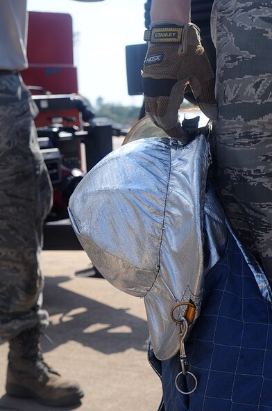 An Airman, 2nd Civil Engineer Squadron Fire Department, holds the helmet of his fire proximity gear during egress training on Barksdale Air Force Base, La., Sept. 21. The National Fire Protection Agency requires proximity gear for all crash fire rescues. Proximity gear is used to reflect heat as opposed to absorbing it and prevents the wearer from getting burned. (U.S. Air Force photo/Senior Airman Kristin High)(RELEASED)