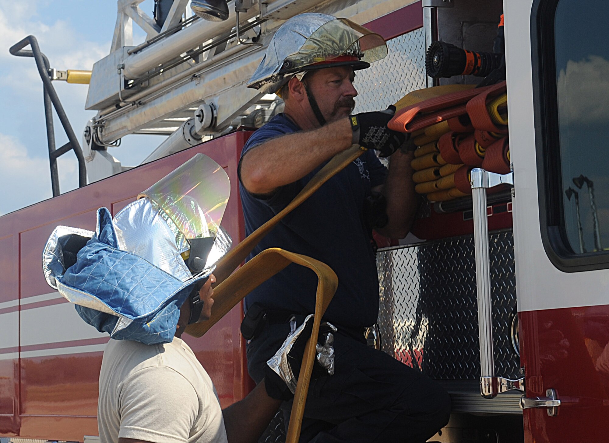 Timothy Radcliff and Airman 1st Class Shelby Bonds, 2nd Civil Engineer Squadron Fire Department, re-load fire attack handlines onto a fire truck during egress training on Barksdale Air Force Base, La., Sept. 21. The flatlines are folded, rather than wrapped, so when the firefighters are running, they do not get tangled. (U.S. Air Force photo/Senior Airman Kristin High)(RELEASED)