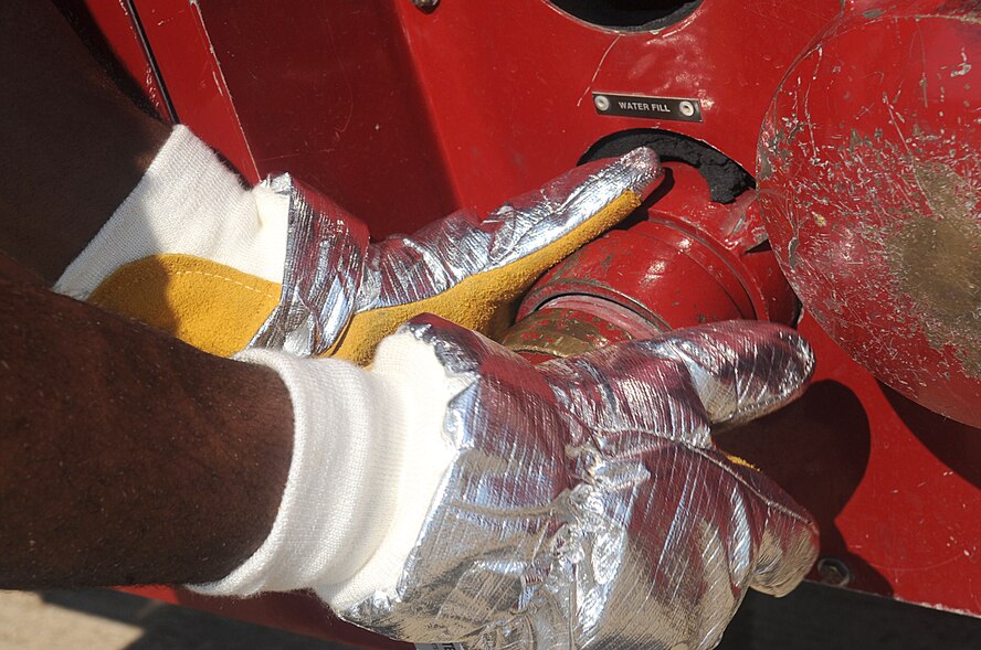Airman 1st Class Frederick Chavis II, 2nd  Civil Engineer Squadron Fire Department tail board, re-services a P-19 fire truck during egress training on Barksdale Air Force Base, La., Sept. 21. The water fill is connected to a hydrant to resupply the crash trucks so they do not run out of water while Airmen fight fires on aircraft. (U.S. Air Force photo/Senior Airman Kristin High)(RELEASED)