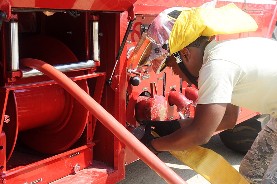 Airman 1st Class Frederick Chavis II, 2nd  Civil Engineer Squadron Fire Department tail board, re-services a P-19 fire truck during egress training on Barksdale Air Force Base, La., Sept. 21. The water fill is connected to a hydrant to resupply the crash trucks so they do not run out of water while Airmen fight fires on aircraft. (U.S. Air Force photo/Senior Airman Kristin High)(RELEASED)