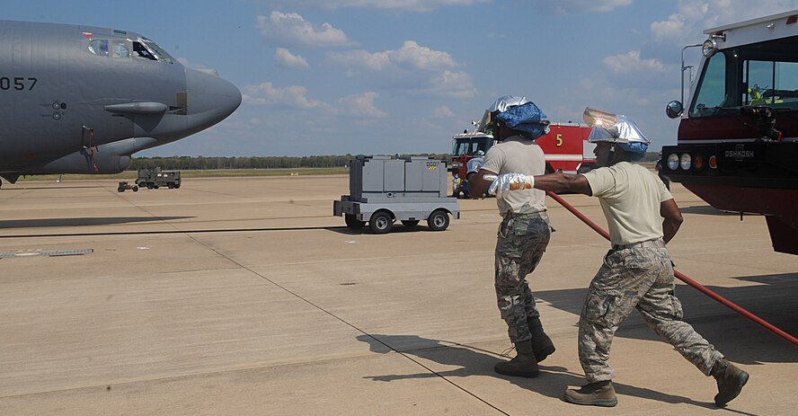 Airman 1st Class Shelby Bonds and Tech Sgt. Carlos Jackson, 2nd Civil Engineer Squadron Fire Department, deploy a handline to a B-52H Stratofortress during egress training on Barksdale Air Force Base, La., Sept. 21. Although the water was not turned on during this training, it's simulated so Airmen are prepared for "real world" incidents. (U.S. Air Force photo/Senior Airman Kristin High)(RELEASED)