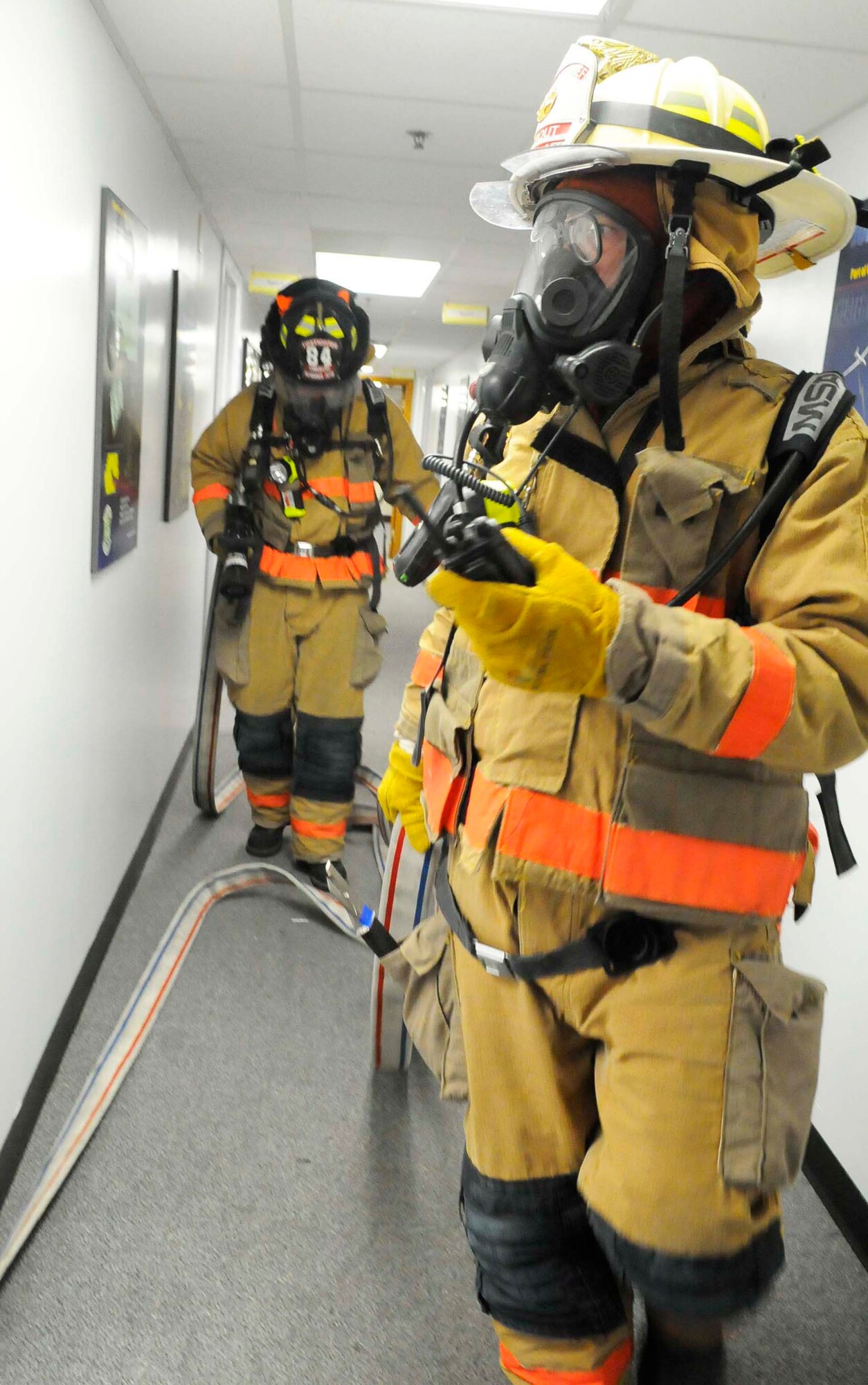 Ronald Strout, Station chief, (foreground) and Mark Gibson, Robins firefighter, do a search through  Bldg. 301 in response to a simulated structure fire there Sept. 15 during Operationa Readiness Exercises. U. S. Air Force photo by Sue Sapp