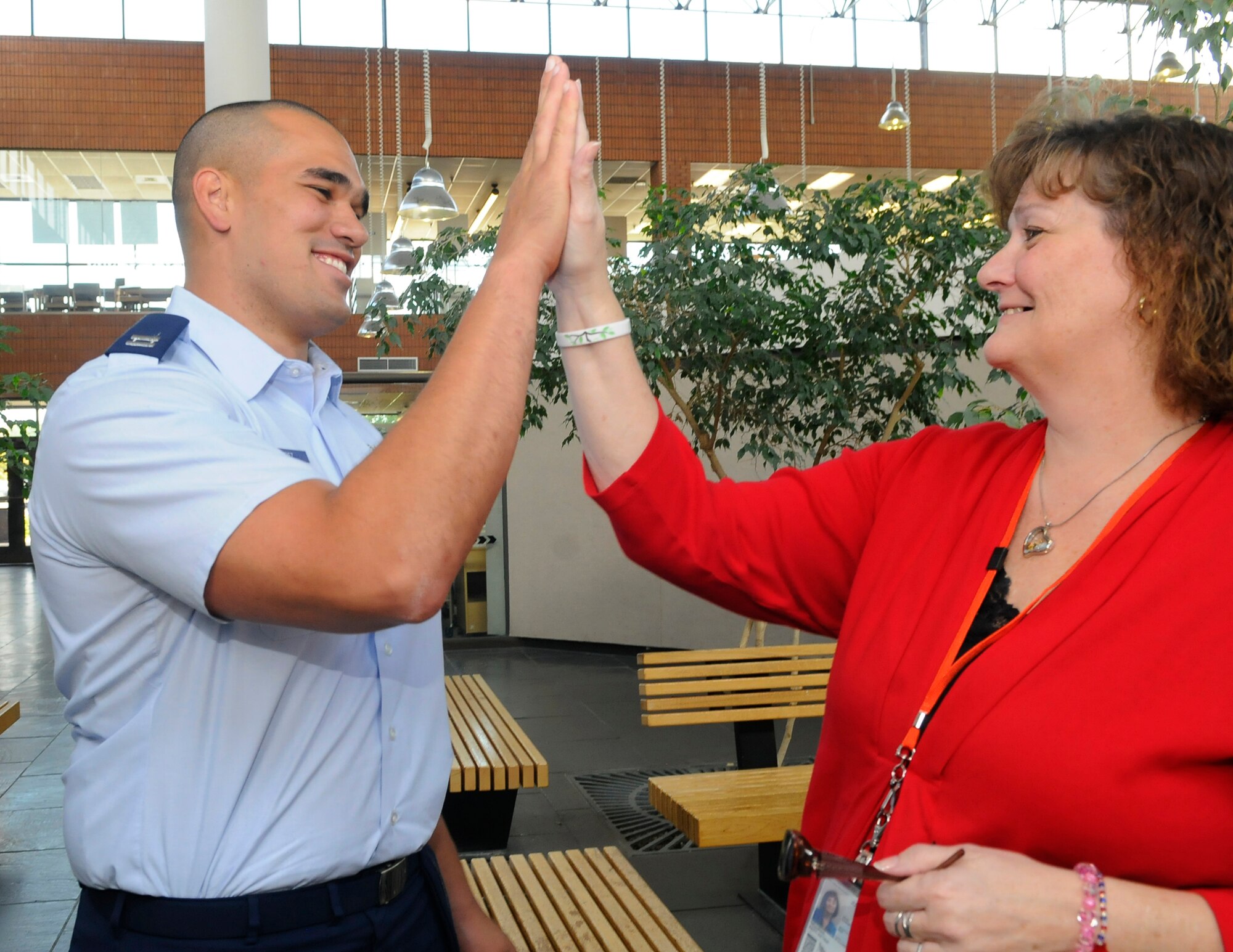Capt. Gilberto Perez and Patti Williams give each other a high-five. Capt. Perez performed the Heimlich maneuver on Williams when he noticed she was in distress while eating a sandwich. U. S. Air Force photo by Sue Sapp