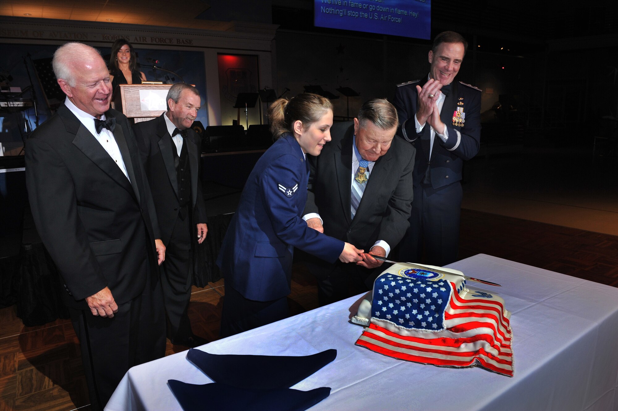 Airman 1st Class Blair Sel, the most junior Airman attending the birthday celebration,  and retired Col. Joe Jackson, a medal of honor recipient, cut the cake as ( from left), U.S. Sen Saxby Chambliss, retired Lt. Col. Mike Trotter and Maj. Gen. Robert McMahon, Warner Robins Air Logistics Center commander, look on. Jackson was a special guest at the celebration. U. S. Air Force photo by Gary Cutrell