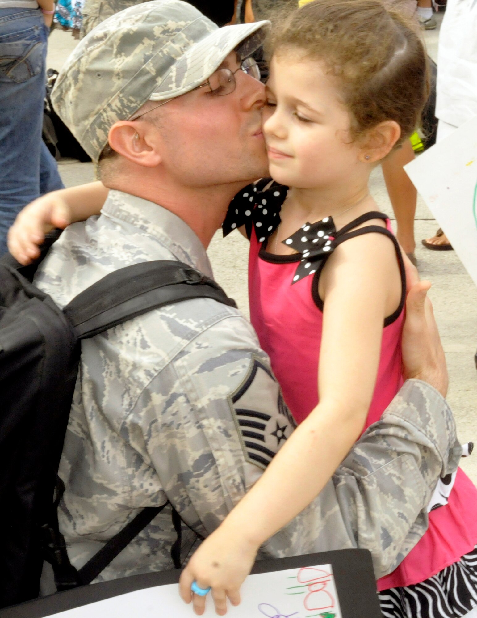 Master. Sgt Albert Foley, 603rd Air Control Squadron assistant NCO in charge of ground radar systems, greets his 5-year-old daughter Tayla with a hug and a kiss after returning from a six month deployment. Airmen from the 603rd Air Control Sqaudron deployed to four different locations in support of Operation New Dawn.(U.S. Air Force photo/Airman 1st Class Briana Jones)