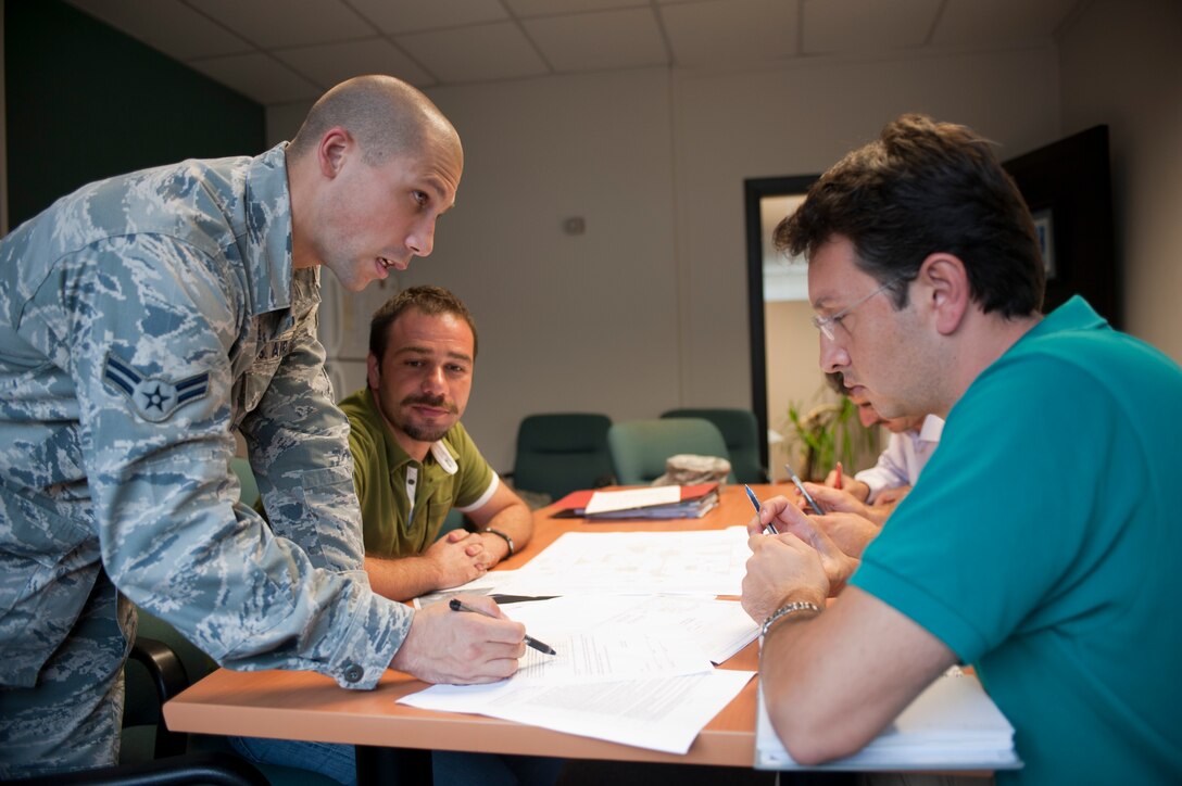 Airman 1st Class Eric Punjabi, 39th Contracting Squadron contract administrator, reviews a project package with contractors and technical experts Sept. 22, 2011, at Incirlik Air Base, Turkey. The contracting squadron's primary mission is divided into the services and commodities flight and infrastructure flight. The flights prepare project packages for every contract on base. (U.S. Air Force photo by Senior Airman Clayton Lenhardt/Released)