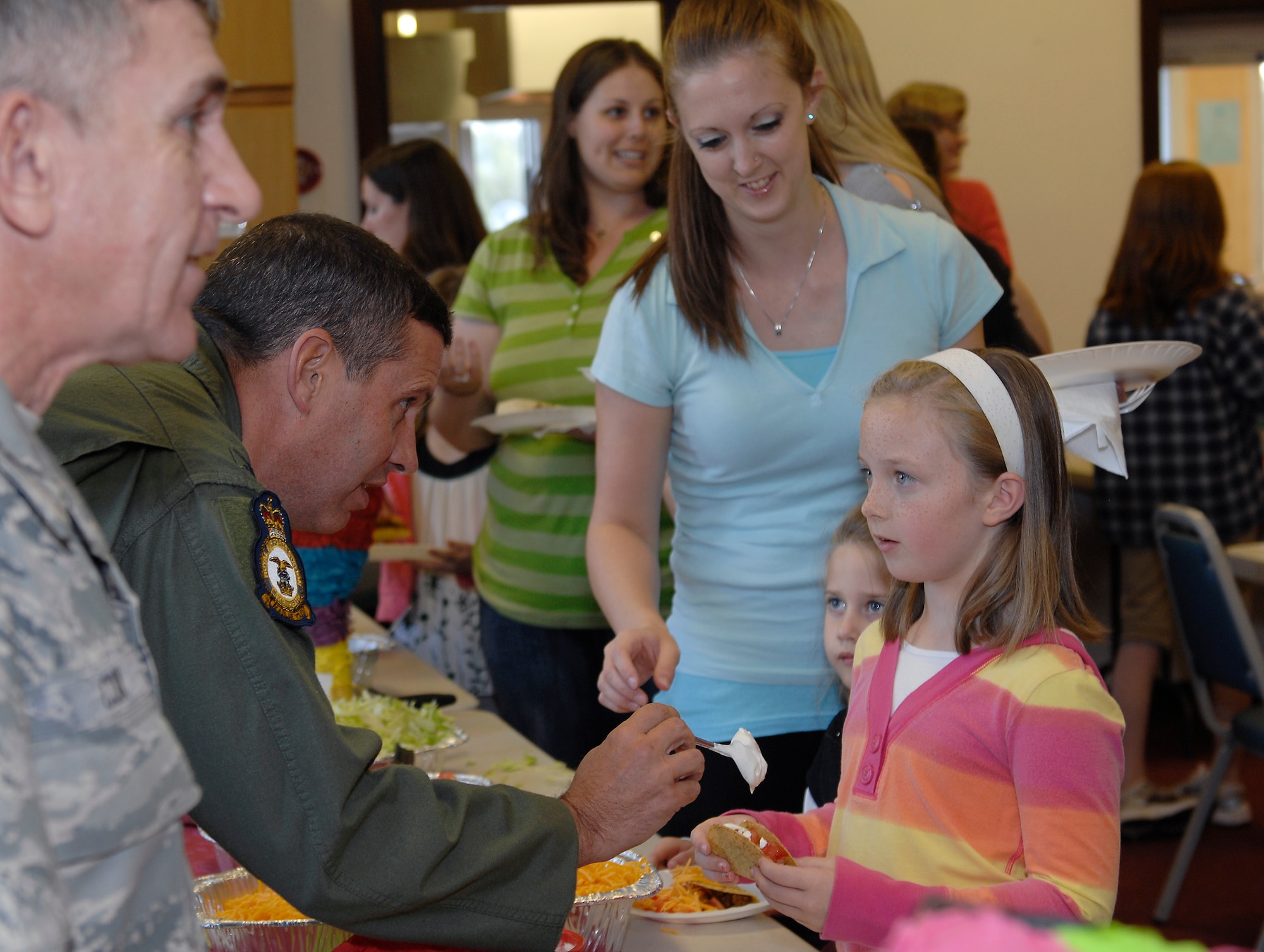 ROYAL AIR FORCE LAKENHEATH, England - Col. William Lewis, 48th Fighter Wing vice commander talks with 8-year-old Arley Garrison during the deployed family dinner Sept. 21, 2011.  The base hosts the special dinner quarterly to create an open environment for the spouses and children to meet, mingle and show support while their loved ones are away.  (U.S.  photo by Tech. Sgt. Lee A. Osberry Jr.)