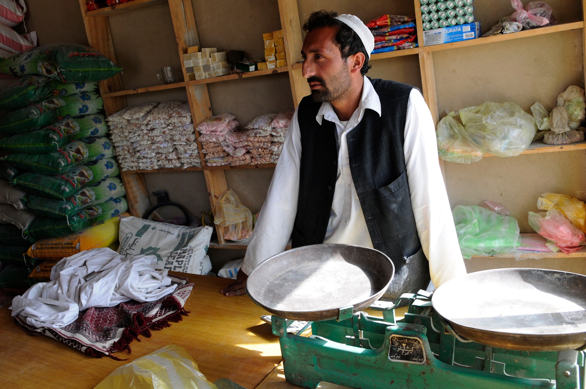 A local Afghan shop owner talks with members of Provincial Reconstruction Team Paktya during a quality assurance visit to the Ahmad Abad district market, Sept. 18, 2011. Members of Provincial Reconstruction Team Paktya met with local villagers in the area to gauge local economic progress.  (U.S. Air Force photo/Senior Airman Wesley Farnsworth) 
