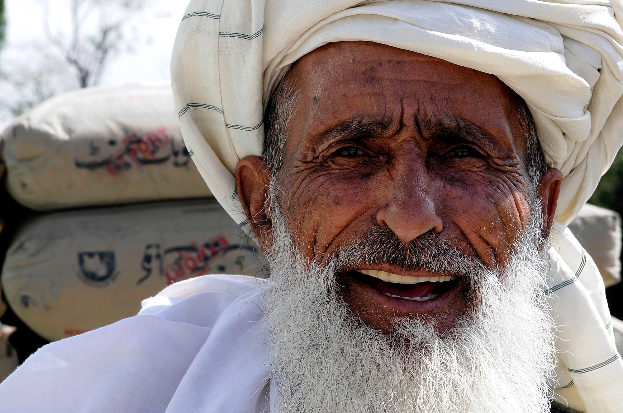 An Afghan elder smiles outside a shop in the Ahmad Abad district market, Sept. 18, 2011. U.S. Air Force members of Provincial Reconstruction Team Paktya visited the market to gauge the local economy and security in the area. (U.S. Air Force photo/Senior Airman Wesley Farnsworth) 
