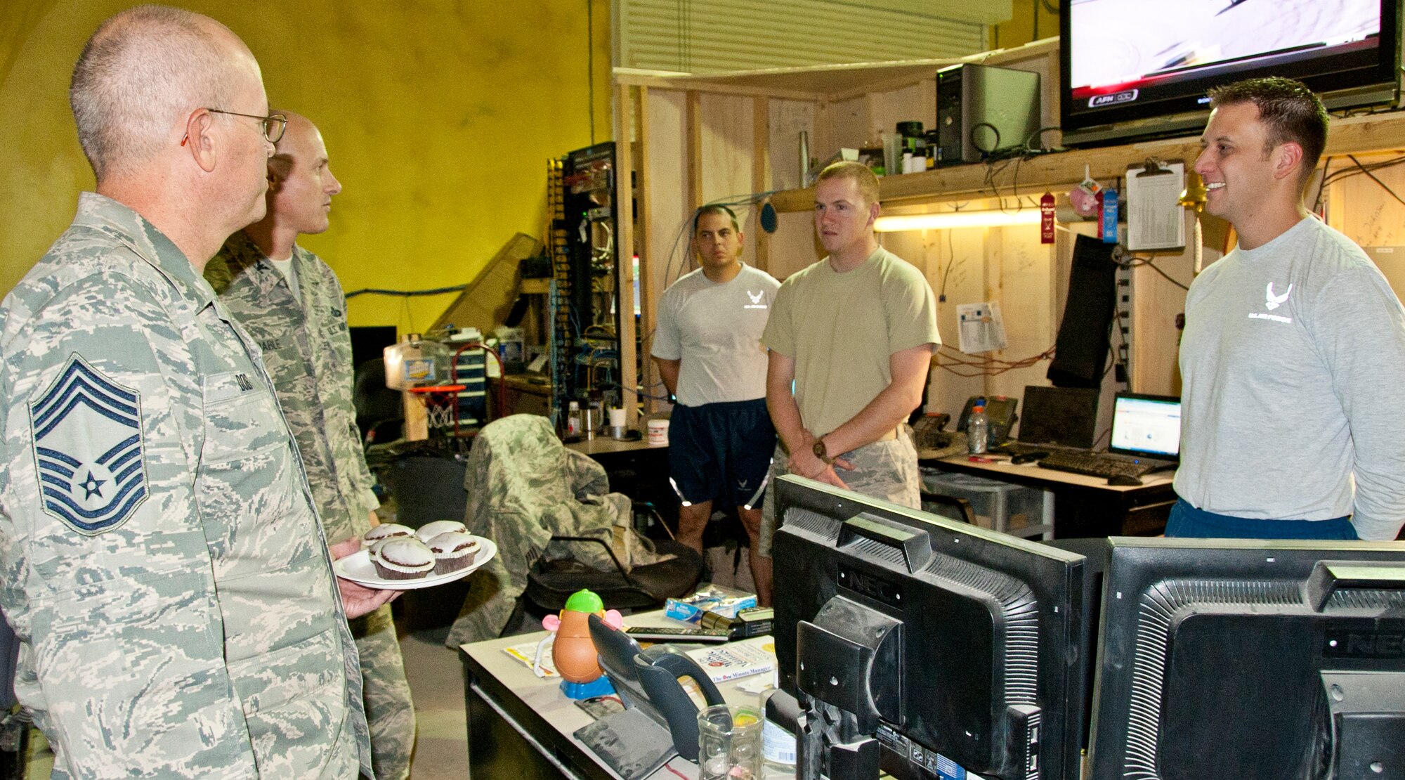 KANDAHAR AIRFIELD, Afghanistan -- Chief Master Sgt. Glenn Doby and Col. Samuel Grable, 451st Expeditionary Mission Support Group, visit with members of the 451st Expeditionary Communications Squadron Sept. 18, 2011. Grable and Doby handed out cupcakes and cookies to members of the 451st Air Expeditionary Wing who could not attend the Air Force Birthday Bash at Camp Losano. Grable and Doby visited nine units and wished them a happy Air Force birthday. (U.S. Air Force photo by Senior Airman David Carbajal)