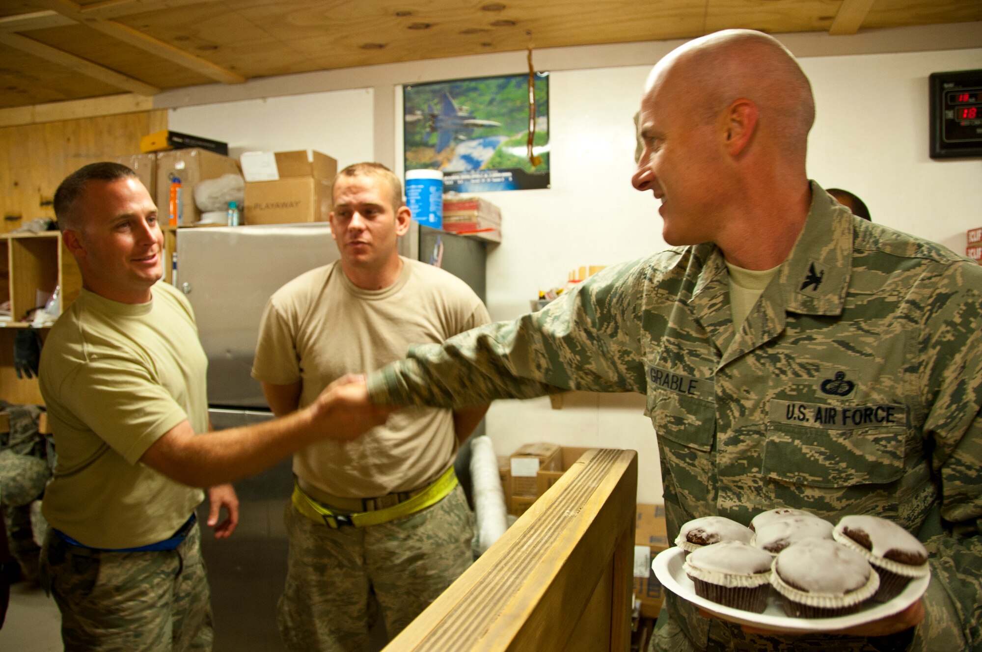 KANDAHAR AIRFIELD, Afghanistan -- Col. Samuel Grable, 451st Expeditionary Mission Support Group commander, shakes hands with a member of 451st Expeditionary Logistics Readiness Squadron vehicle operations flight Sept. 18, 2011. Grable and superintendent Chief Master Sgt. Glenn Doby handed out cupcakes and cookies to members of the 451st Air Expeditionary Wing who could not attend the Air Force Birthday Bash at Camp Losano. Grable and Doby visited nine units and wished them a happy Air Force birthday. (U.S. Air Force photo by Senior Airman David Carbajal)