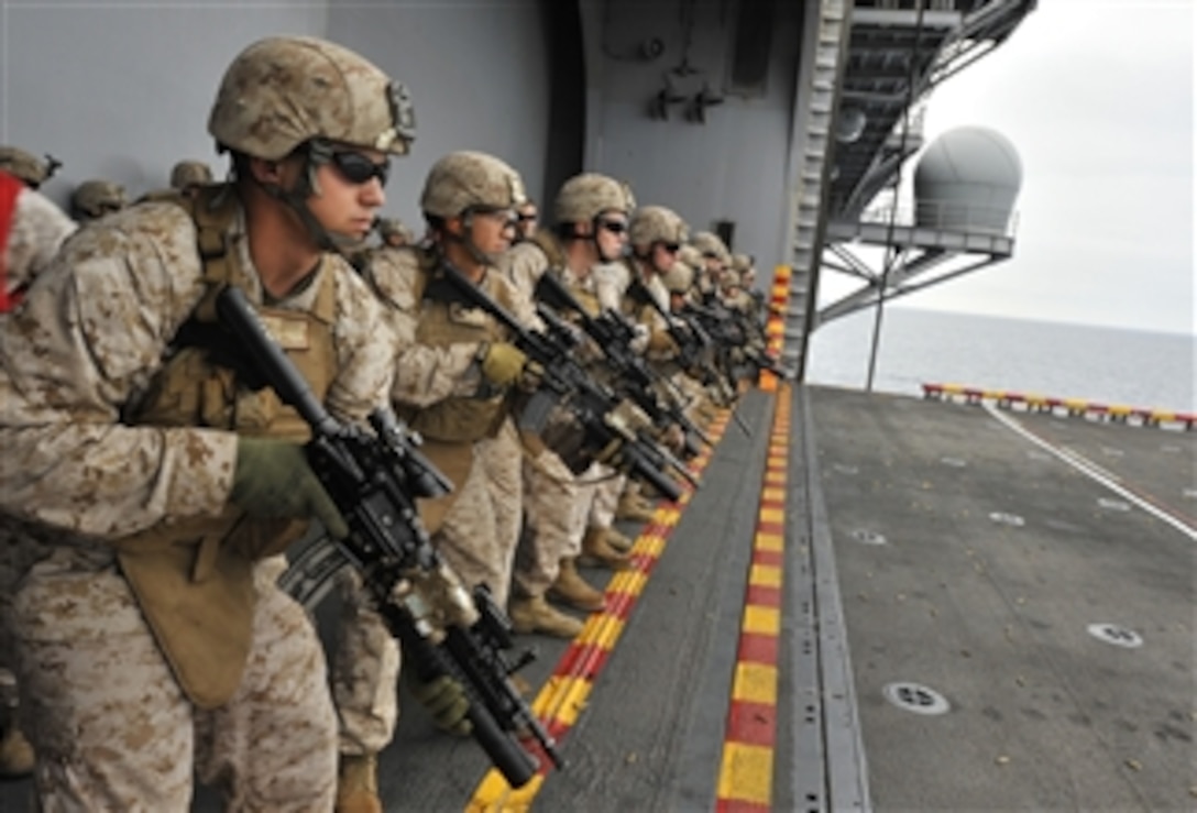 U.S. Marines assigned to the 11th Marine Expeditionary Unit stand at the ready during a live-fire exercise aboard the amphibious assault ship USS Makin Island (LHD 8) as the ship operates in the Pacific Ocean off the coast of Southern California on Sept. 10, 2011.  The Makin Island Amphibious Ready Group is conducting a composite training unit exercise, which is designed to test capabilities and ensure overall readiness before deployment.  