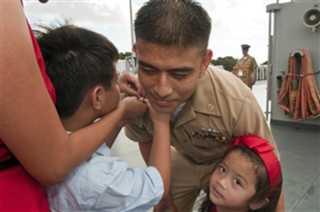 U.S. Navy Chief Petty Officer Kim Mercado has his chief petty officer anchors pinned on his collar by his son and daughter at the U.S. 7th Fleet chief petty officer pinning ceremony on the USS Blue Ridge (LCC 19) in Yokosuka, Japan, on Sept. 16, 2011.  