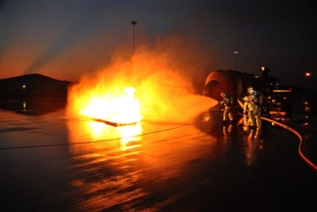Firefighters from the Selfridge Air National Guard Base, Mich., fire department work to extinguish a fire during a training exercise on Sept. 2, 2011.  The firefighters worked on a variety of scenarios involving a fire in and around an aircraft simulator.  
