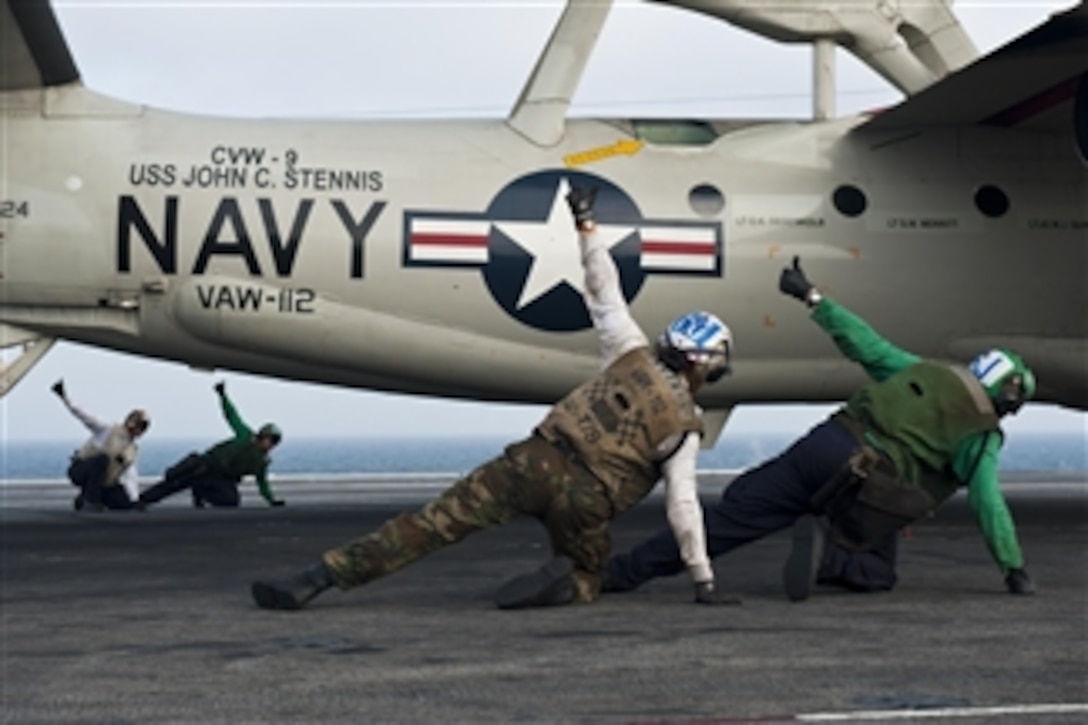 Flight deck crew members give the thumbs up to launch an E-2C Hawkeye from the USS John C. Stennis (CVN 74) as the aircraft carrier conducts flight operations in the Indian Ocean on Sept. 17, 2011.  Stennis is deployed to the U.S. 5th Fleet area of responsibility to conduct maritime security operations and support missions as part of Operation Enduring Freedom and New Dawn.  The Hawkeye is attached to Airborne Early Warning Squadron 112.  