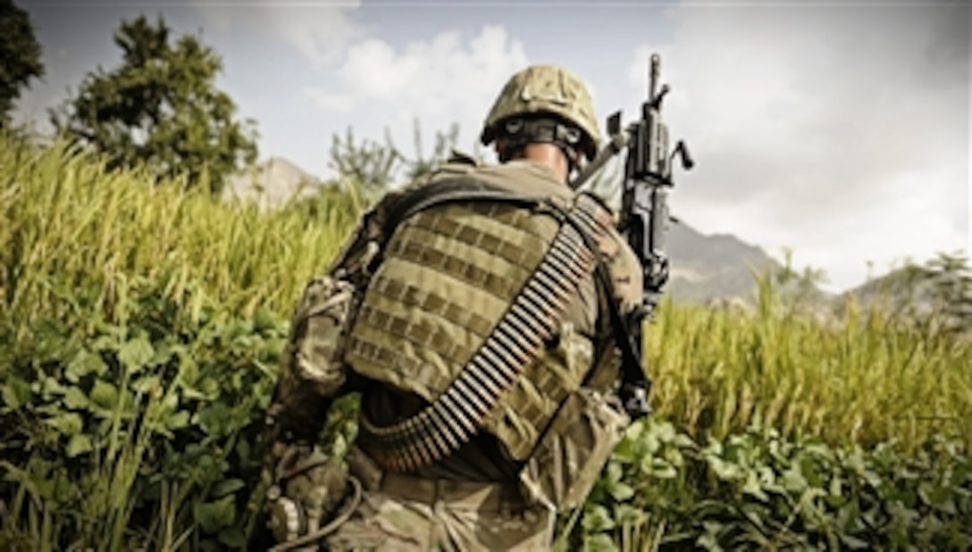 U.S. Army Spc. Jake Amato, an MK48 machine gunner assigned to Laghman Provincial Reconstruction Team, patrols through a field looking for triggermen in the Alisheng district, Laghman province, Afghanistan, on Sept. 12, 2011.  