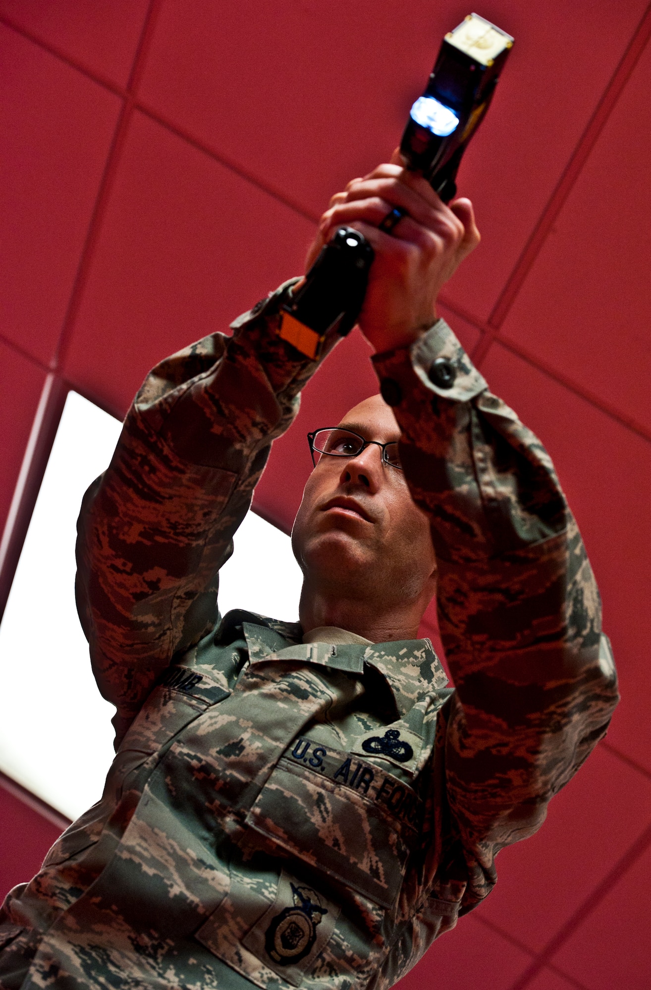 Master Sgt.  William Newcomb, the NCO-in-charge of training for the 96th Security Forces Squadron, fires his X-26 Taser at a target across the room during a demonstration at Eglin Air Force Base, Fla.  All 96 SFS personnel must attend an eight-hour course to carry a taser.  It is required annual training to maintain certification for the device.  16 SFS Airmen and civilians were trained or re-certified through at class Sept. 22.  Six people received exposure to the taser’s 50,000 volts for five seconds to better understand, first-hand, how the body reacts to the shot.  It is not a requirement to receive exposure to the taser to carry the weapon.  (U.S. Air Force photo/Samuel King Jr.)