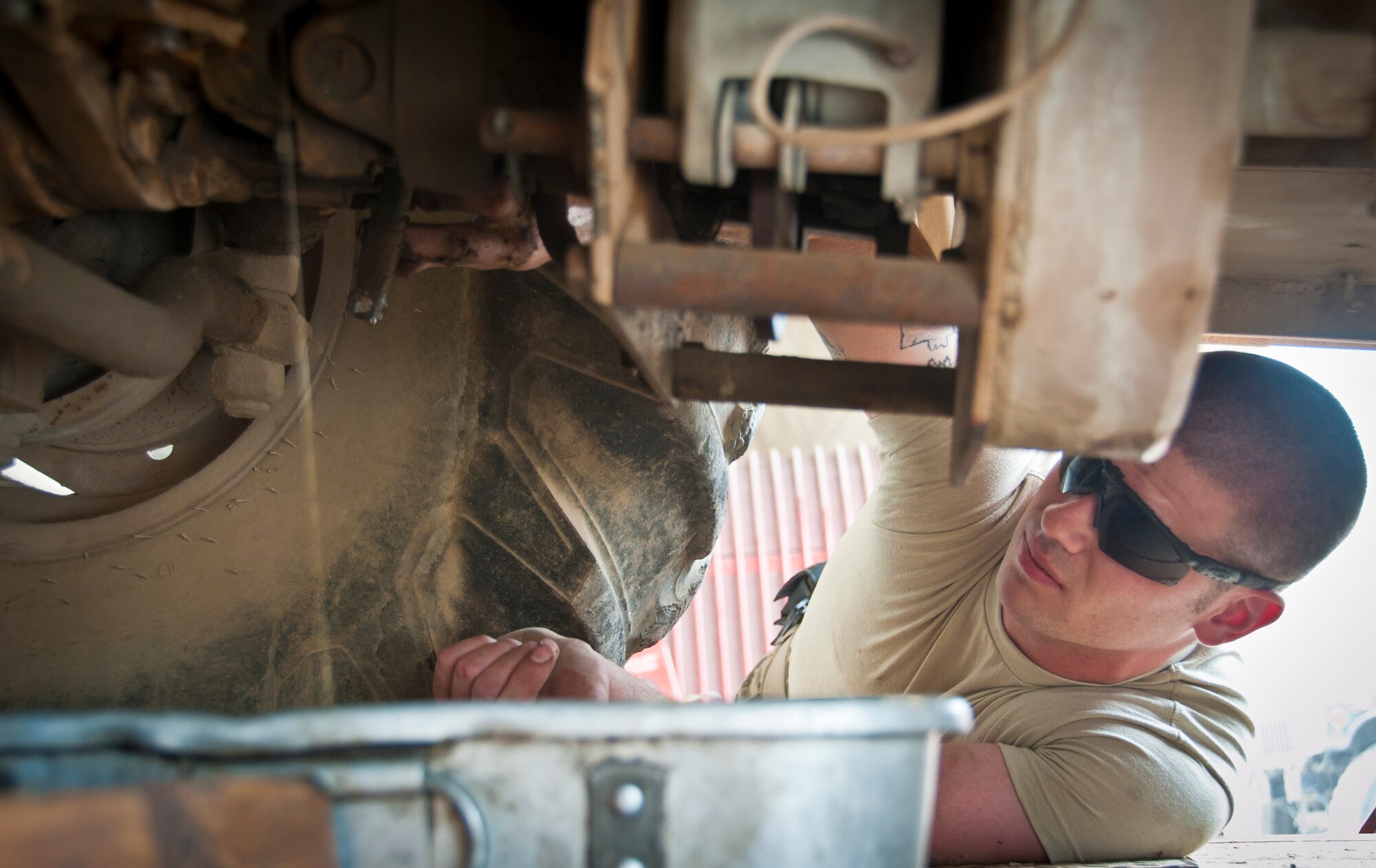 KANDAHAR AIRFIELD, Afghanistan -- Senior Airman Jared Burton, 451st Expeditionary Logistics Readiness Squadron vehicle maintenance, loosens a hydraulic line to drain the fluid at the vehicle maintenance shop here Aug. 23, 2011. Burton prepped the "ditch witch" for Defense Reutilization and Marketing Service turn in. Burton is deployed from Minot Air Force Base, N.D., and is a Clinton, Wis., native. (U.S. Air Force photo by Senior Airman David Carbajal)