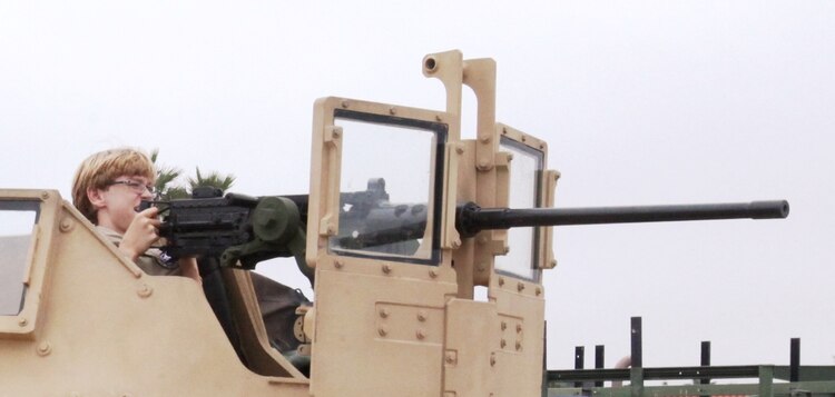 A Boy Scout pretends to be a Marine as he mans the turret of a Humvee in Oceanside, Calif., Sept. 25. The Humvee was part of a static display set up by service members during the annual Harbor Days event.