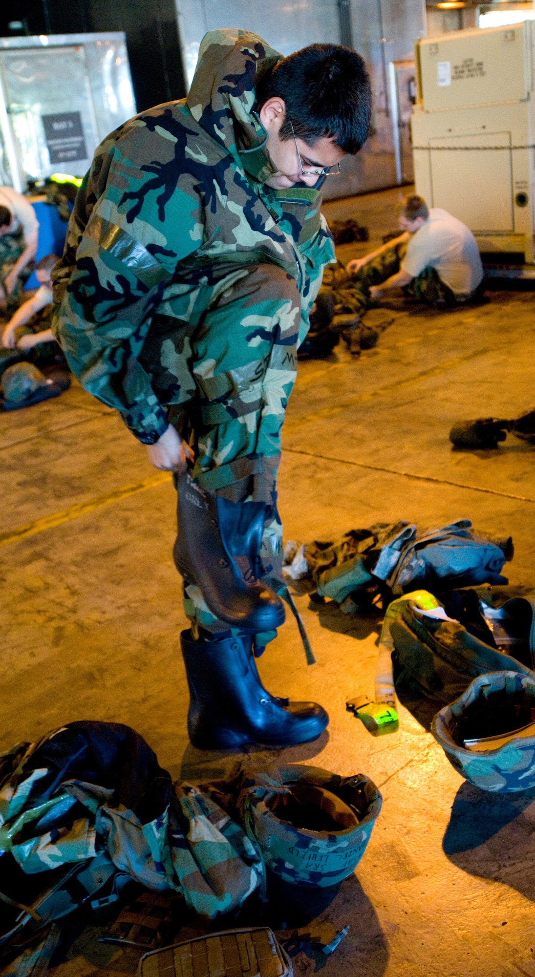 YOKOTA AIR BASE, Japan -- Staff Sgt. Paul Orosco, 730th Air Mobility Squadron crewchief, dons his individual protective equipment during a mission capability and compliance inspection at Yokota Air Base, Japan, Sept. 22, 2011. During an MCCI, units are inspected on their record keeping and daily operations capabilities. (U.S. Air Force photo/Airman 1st Class Krystal M. Garrett) 