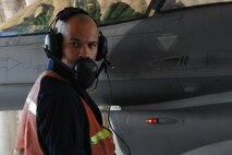 KUNSAN AIR BASE, Republic of Korea -- A crew chief from the 8th Aircraft Maintenance Squadron holds the dead man switch while watching the number of gallons being put into an F-16 during a hot pit refuel here Sept. 21. The dead man switch starts and stops the fuel flow during a refuel. (U.S. Air Force photo/Senior Airman Brittany Y. Bateman)