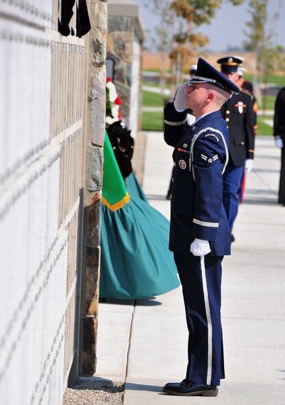 Airman 1st Class Christopher Schafer, Fairchild Honor Guard, salutes after placing the remains of a veteran in the Columbarium Wall during the honor service. (U.S. Air Force Photo/Staff Sgt. Michael Means)