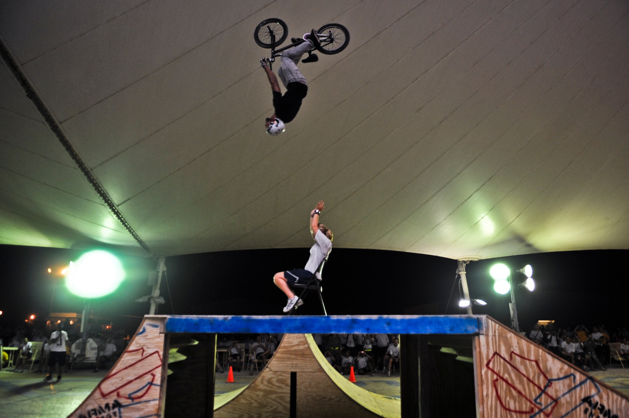 Mykel Larrin performs a back flip over Airman 1st Class Christy Mote, 379th Expeditionary Civil Engineer Squadron civil engineer escort, during the “Bikes over Baghdad” event, Sept. 24, 2011, at an undisclosed location in Southwest Asia.  Mote, a native of Rutherfordton, N.C., is deployed from Seymour Johnson Air Force Base, N.C. (U.S. Air Force photo/Senior Airman Paul Labbe) 