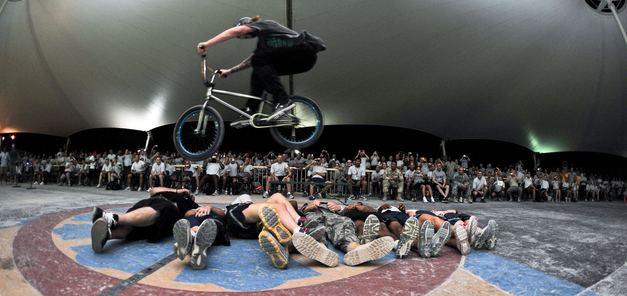 Jeremiah Smith performs a bunny hop stunt over nine volunteers during the “Bikes over Baghdad” tour, Sept. 24, 2011, at an undisclosed location in Southwest Asia.   (U.S. Air Force photo/Senior Airman Paul Labbe)