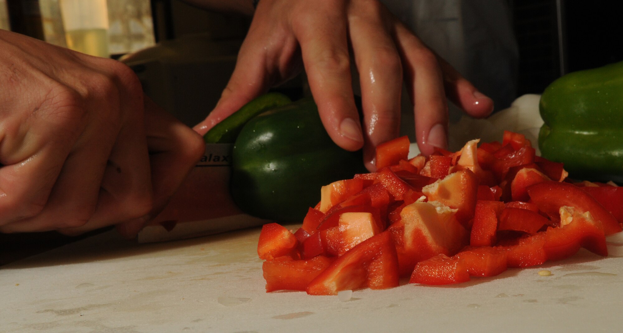 Staff Sgt. Robert Jarvis, 18th Civil Engineer Squadron fireman, cuts a pepper in preparation for making a pasta dish at Fire Station 1 on Kadena Air Base, Japan, Sept. 21. Jarvis prepared his special pasta dish dinner for his fellow firemen, which has become a ritual among the men at Fire Station 1. (U.S. Air Force photo/Airman 1st Class Jarvie Z. Wallace)
