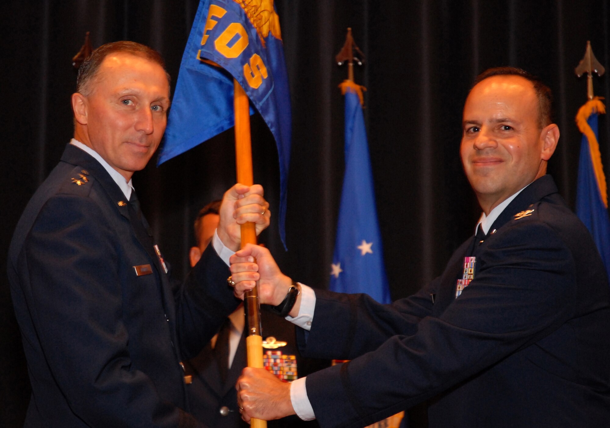 Maj. Gen. William Bender, U.S. Air Force Expeditionary Center commander, presents the Expeditionary Operations School guidon to Col. Patrick Owens on Sept. 26, 2011, during a change of command ceremony at Joint Base McGuire-Dix-Lakehurst, N.J. Owens took command from Col. Mark Ellis. The Expeditionary Operations School is housed at the Expeditionary Center on Joint Base MDL. The school is the Air Force Expeditionary Combat Support Center of Excellence dedicated to educate, train and exercise expeditionary combat support personnel in deployed operations. The school trains Airmen in a variety of combat support roles and ensures students graduate confident and capable of performing their mission across the globe and is responsible for developing and conducting Combat Airman Skills Training, security forces pre-deployment training, mobility intelligence education, and facilitating the Air Force Exercise Eagle Flag. (U.S. Air Force photo/Tech. Sgt. Paul R. Evans)