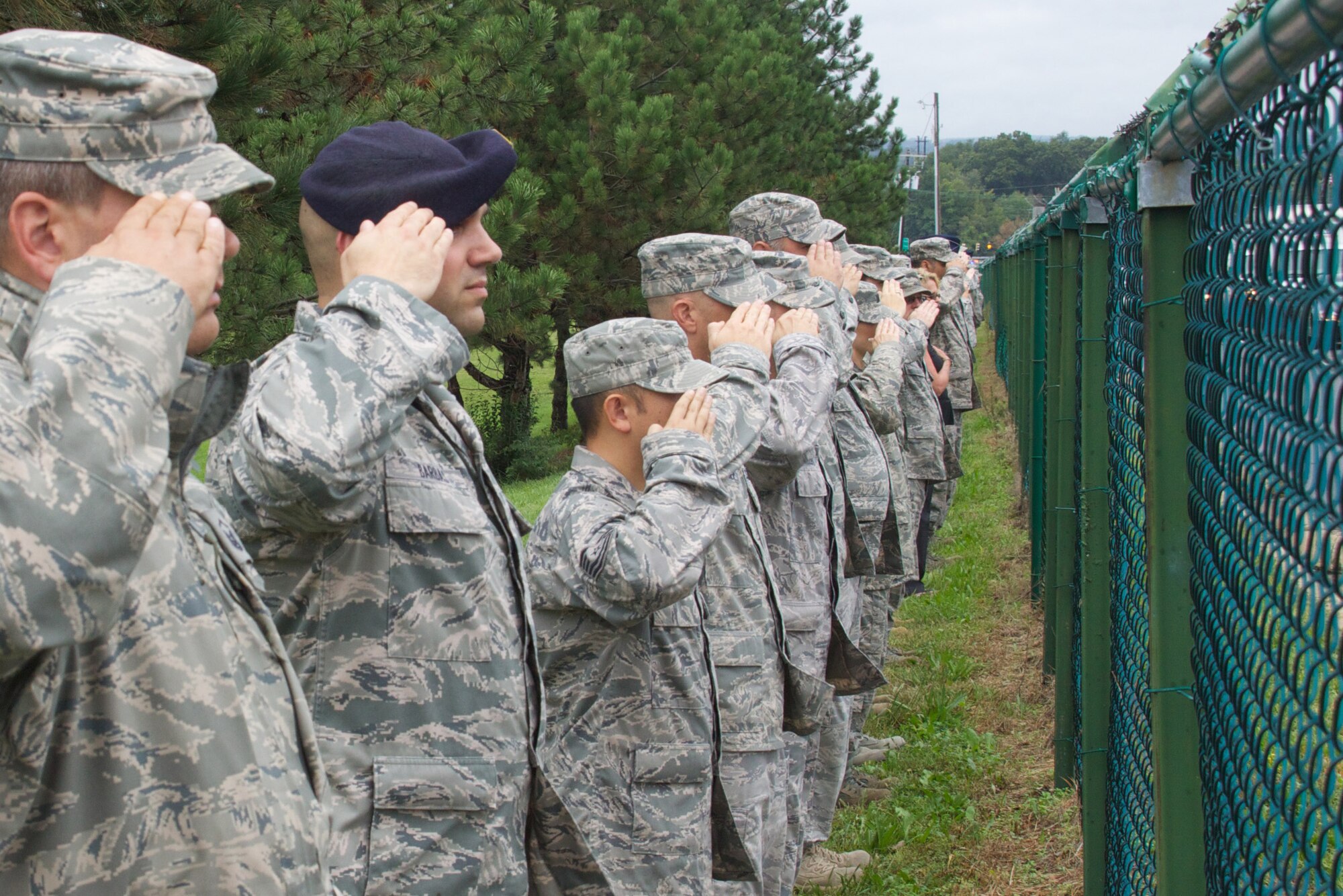 Airmen and civilians from the 166th Airlift Wing of the Delaware Air National Guard pay their final respects on Sept. 23, 2011 for slain New Castle County Police officer Lt. Joseph L. Szczerba whose funeral procession drove on Basin Road past the New Castle ANG Base, New Castle, Del. Officer Szczerba was killed in the line of duty on Sept. 16, 2011. (U.S. Air Force photo/Tech. Sgt. Lionel Castellano)